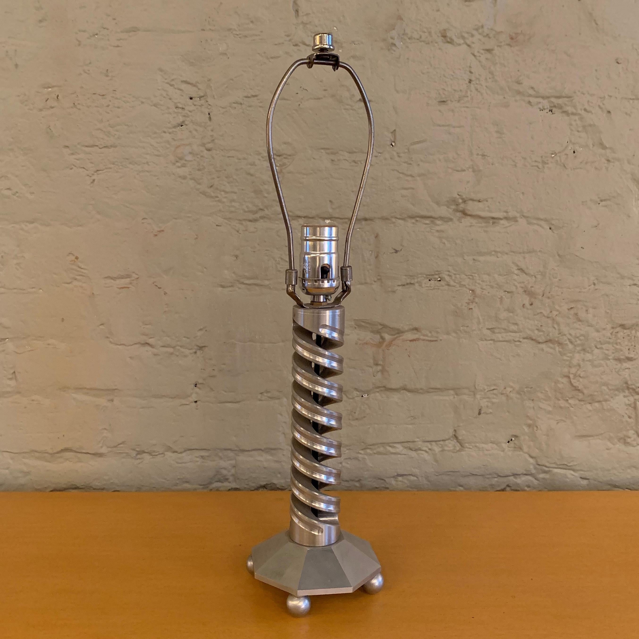 Interesting, machine-age, machined aluminium, table lamp features a spiral stem with faceted base on balled feet. Height to the top of the socket is 12 inches.