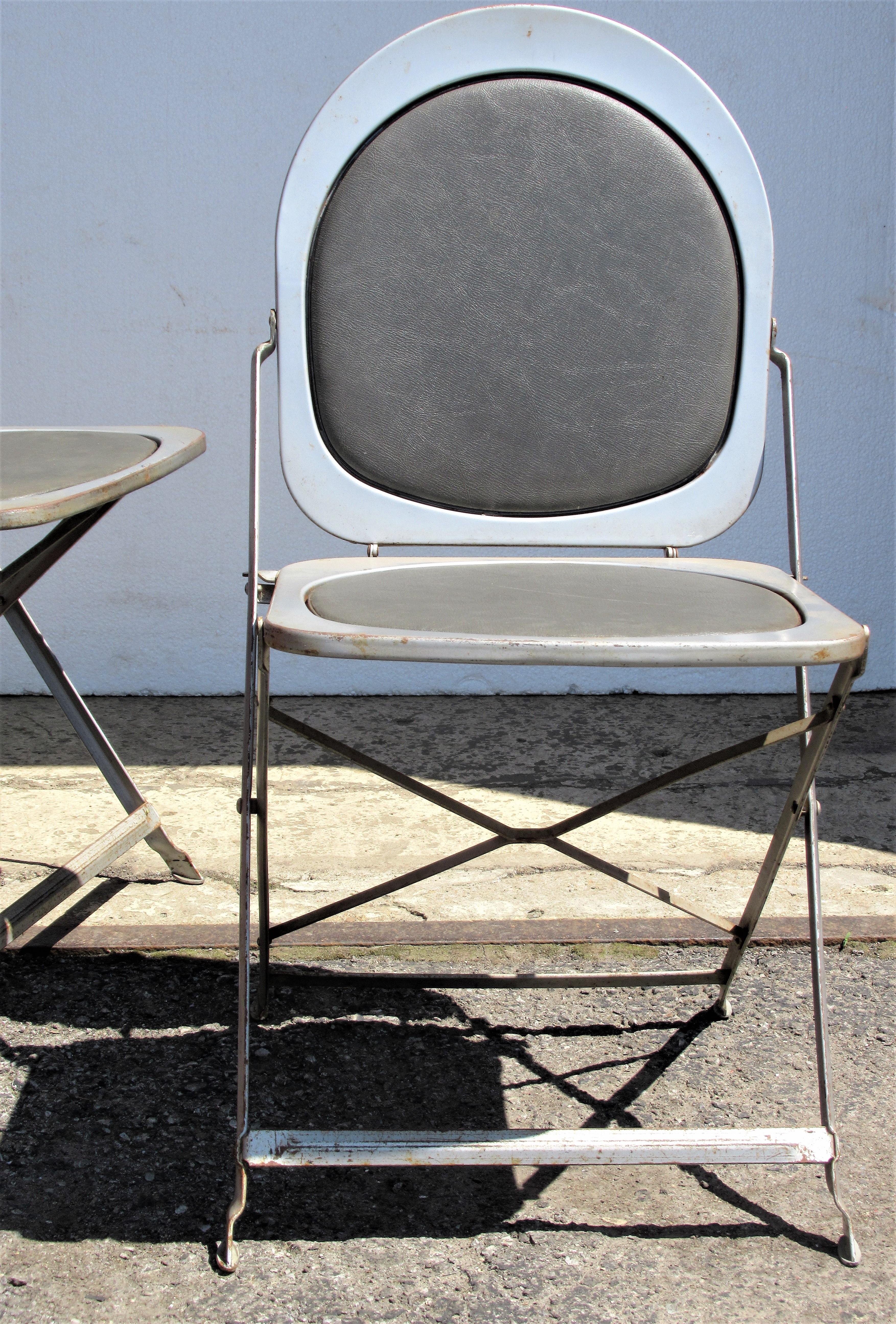 Pair of 1940s industrial machine age silvered steel folding chairs with great architectonic form and all original beautifully aged finish to metal and the oil cloth upholstered seats and backs. Look at all pictures and read condition report in
