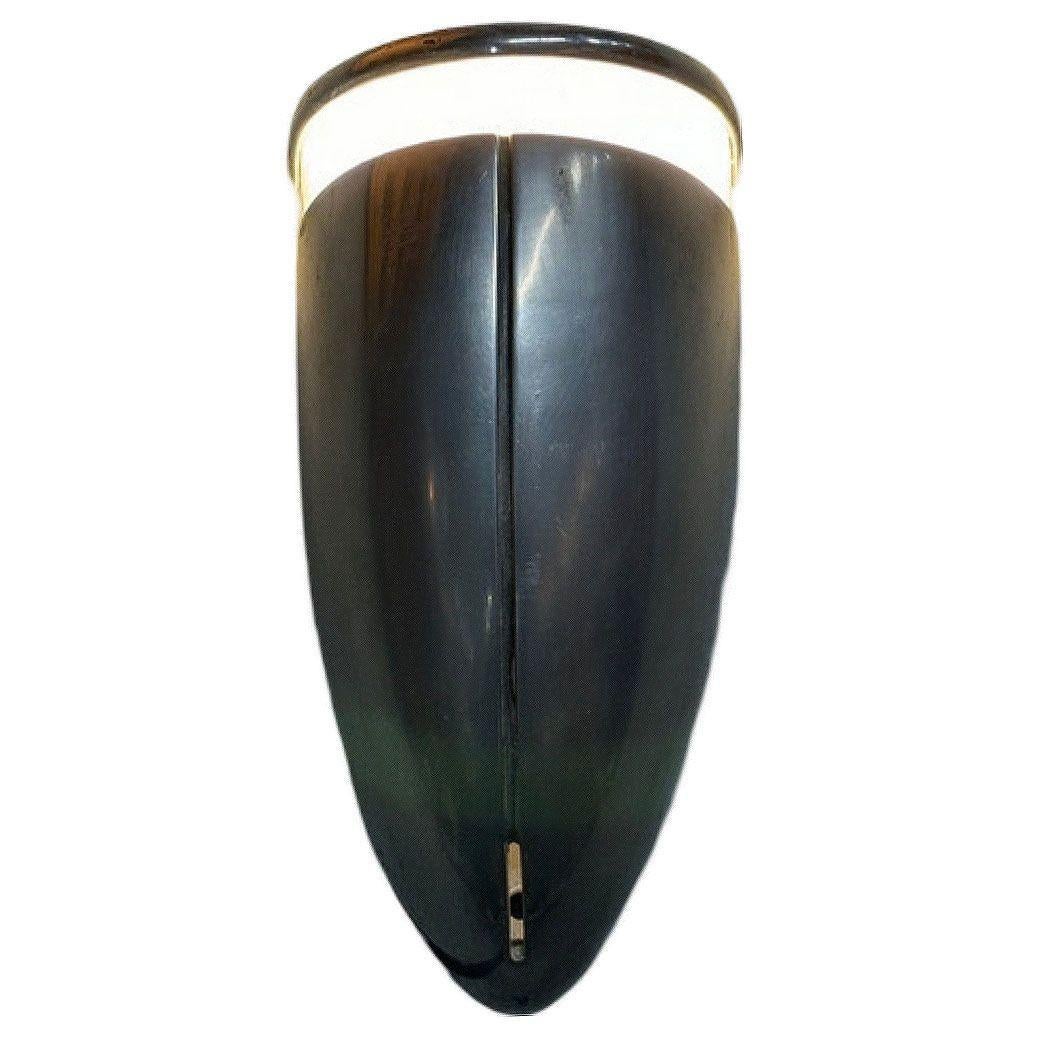 Un'applique Streamline Art Deco in alluminio spazzolato con un corpo rotondo e un ritaglio di vetro per un'illuminazione d'accento lungo la parte superiore.
Queste lampade evocano i design della prima epoca moderna, come quelli di Raymond Loewy e