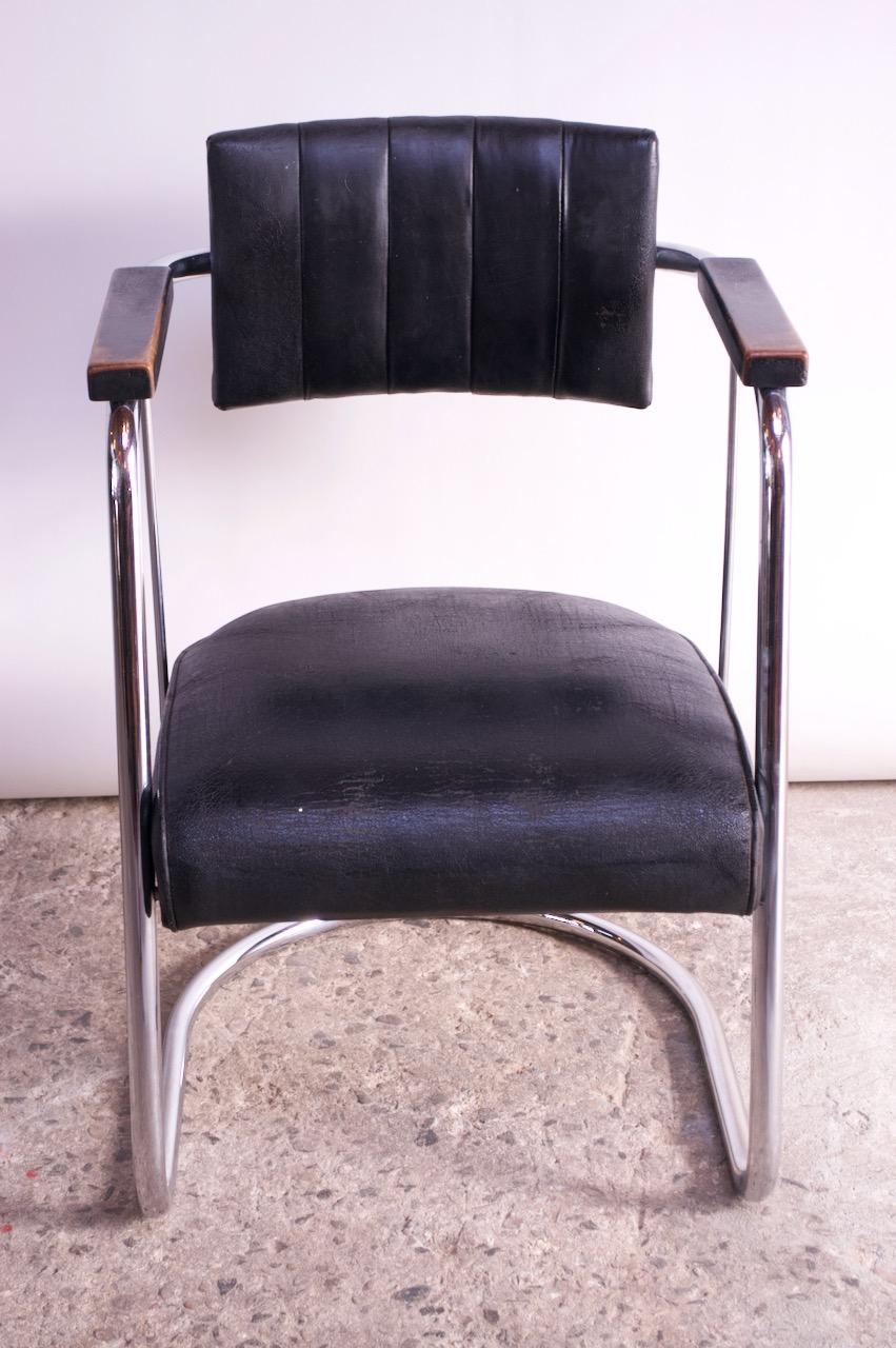 Early 1930s American Art Deco / Machine Age armchair in the style of Gilbert Rohde or Mies van der Rohe, but designer is unknown.
Features a black leather seat / back rest and ebonized wooden armrests, all supported by a tubular-chrome,