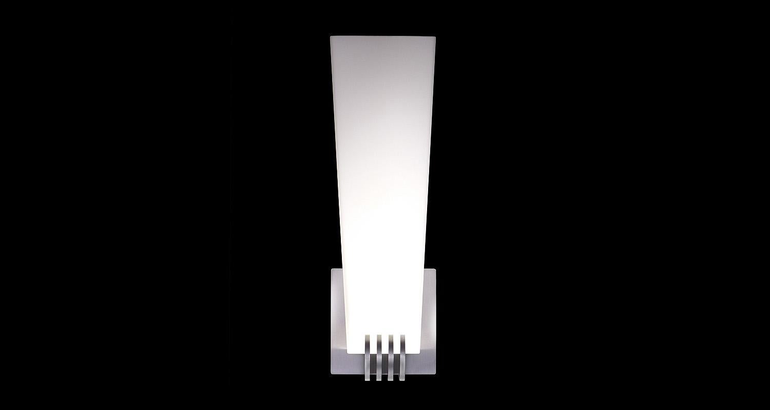 Square tapered glass shade with machined aluminum holder. Metal fins in the manner of streamline moderne. LED lamping, standard color temperature 3000k.

Architect, Sandy Littman of Duesenberg LTD. and The American Glass Light Company have been