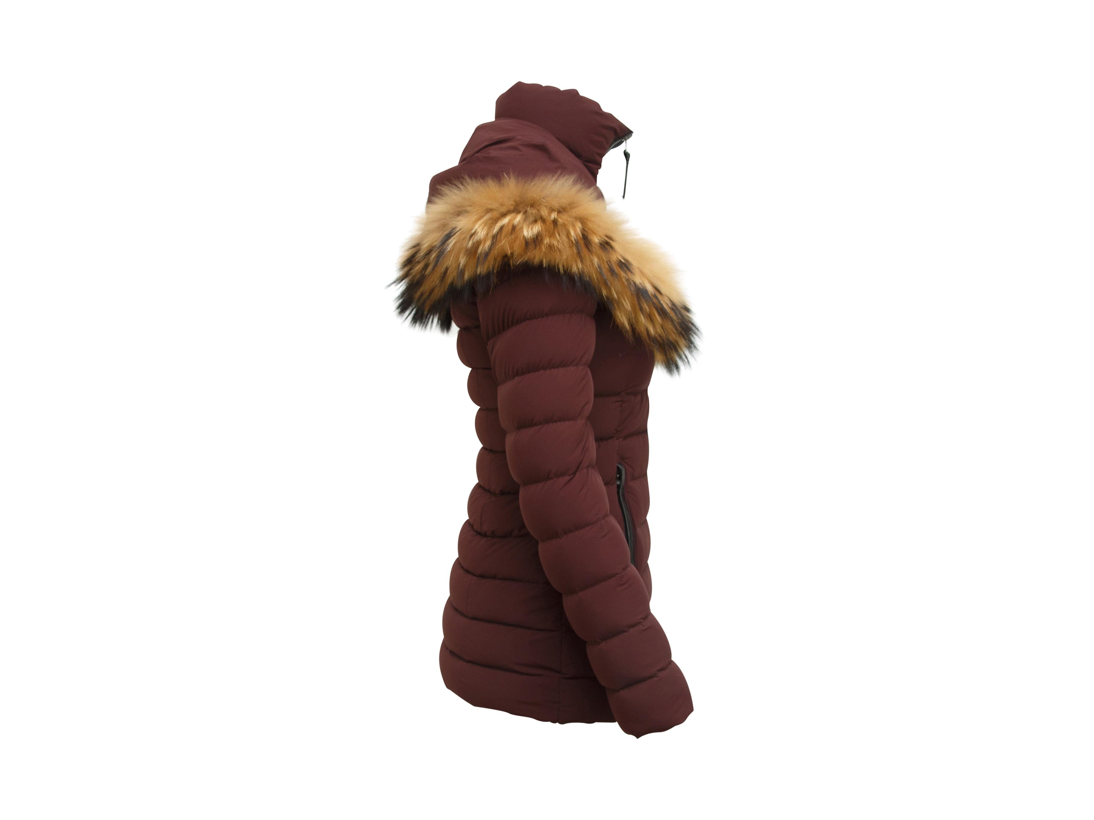 Product details:  Burgundy hooded puffer coat by Mackage.  Trimmed with black leather.  Fox fur trimmed hood.  Stand collar.  Long sleeves.  Zip-front closure.  On-seam waist slide pockets.  34