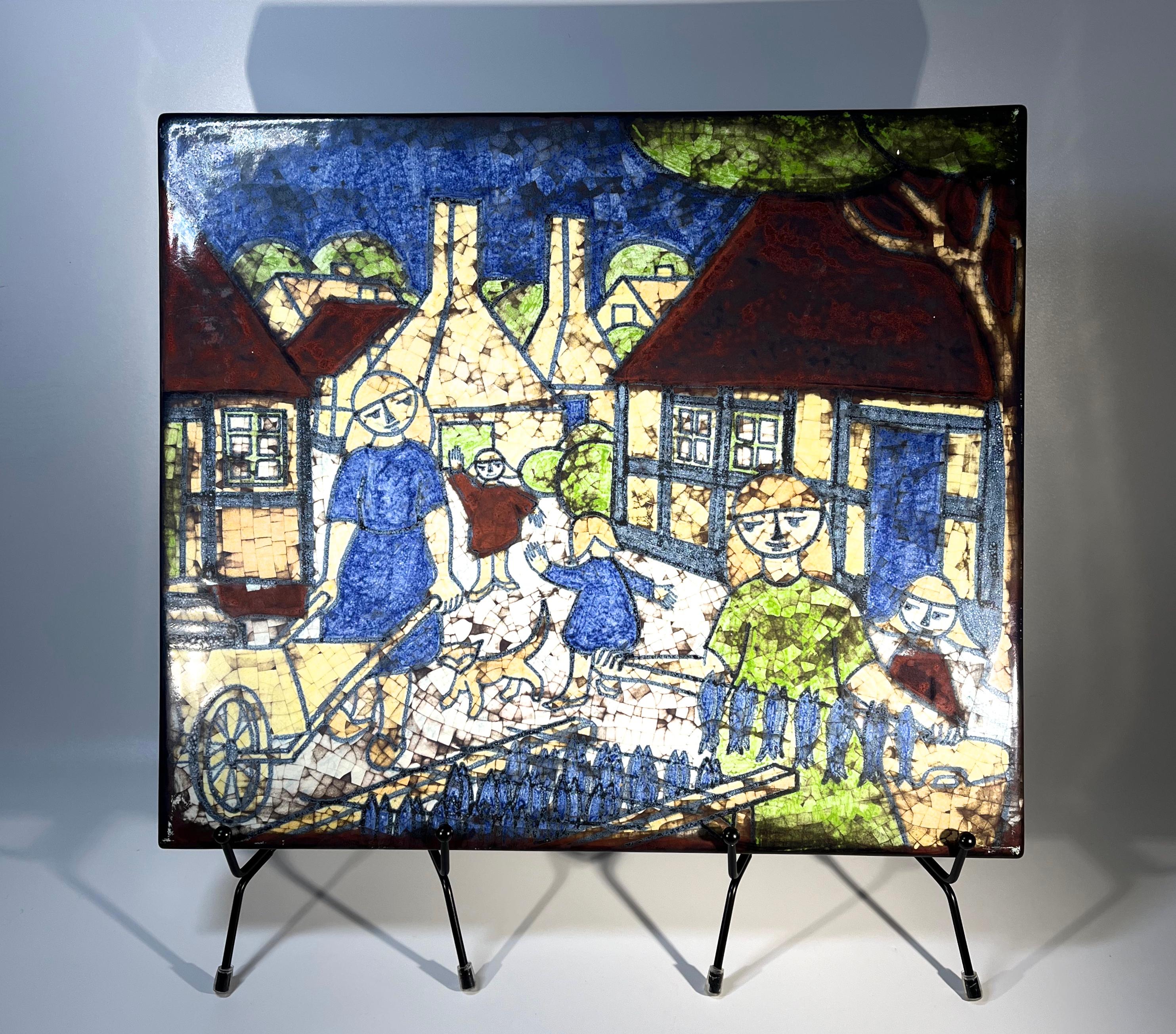 Unterhaltsame Szene mit einem Bornholmer Makrelenräucherer und seiner Familie  
Wunderschön gestaltet  Wandtafel mit einer komplexen persischen Glasur, von der bekannten Keramikerin Marianne Starck, für Michael Andersen, Dänemark 
Rückseitig
