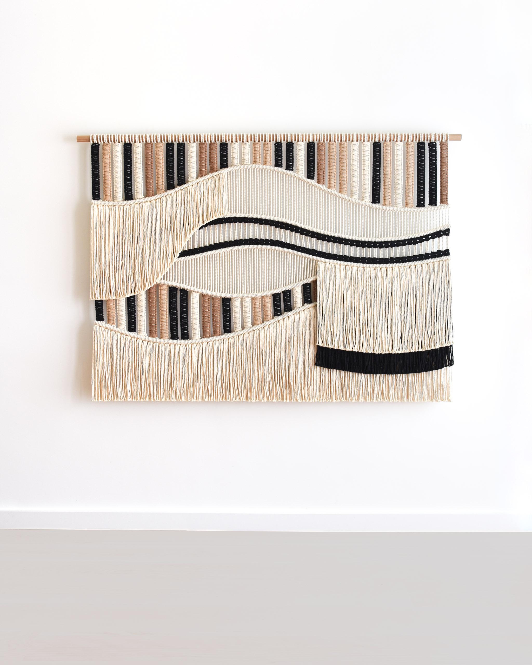 FLOW è un arazzo di fiber art realizzato con centinaia di nodi, una tecnica nota anche come macrame.
Il design è un'esplorazione della forma e della consistenza, esaminando l'interazione tra linee fluide e sezioni stratificate per ottenere un'opera