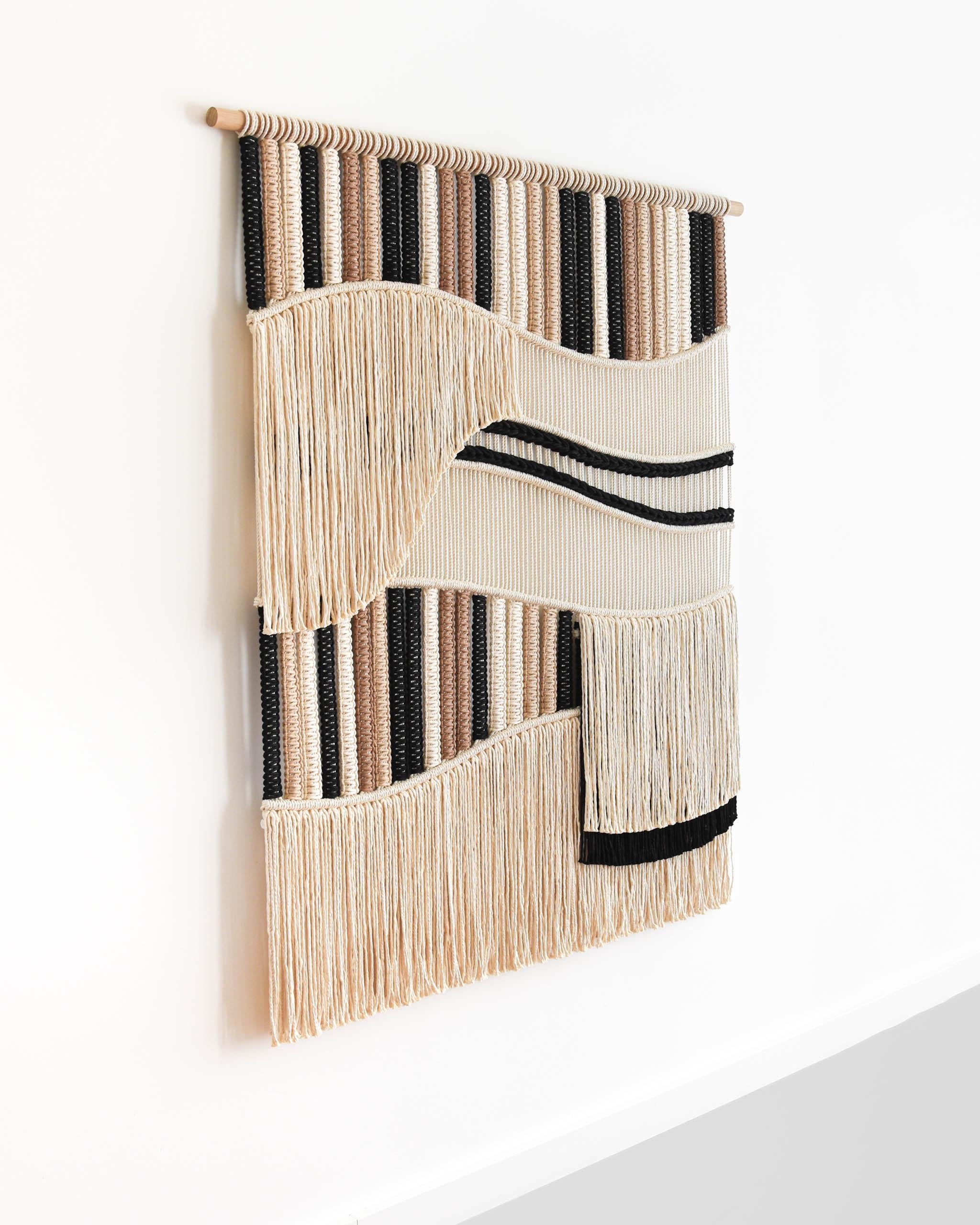 FLOW ist ein Wandteppich aus hunderten von Knoten, eine Technik, die auch als Makramee bekannt ist.
Das Design ist eine Erkundung von Form und Textur, bei der das Zusammenspiel von fließenden Linien und geschichteten Abschnitten untersucht wird, um