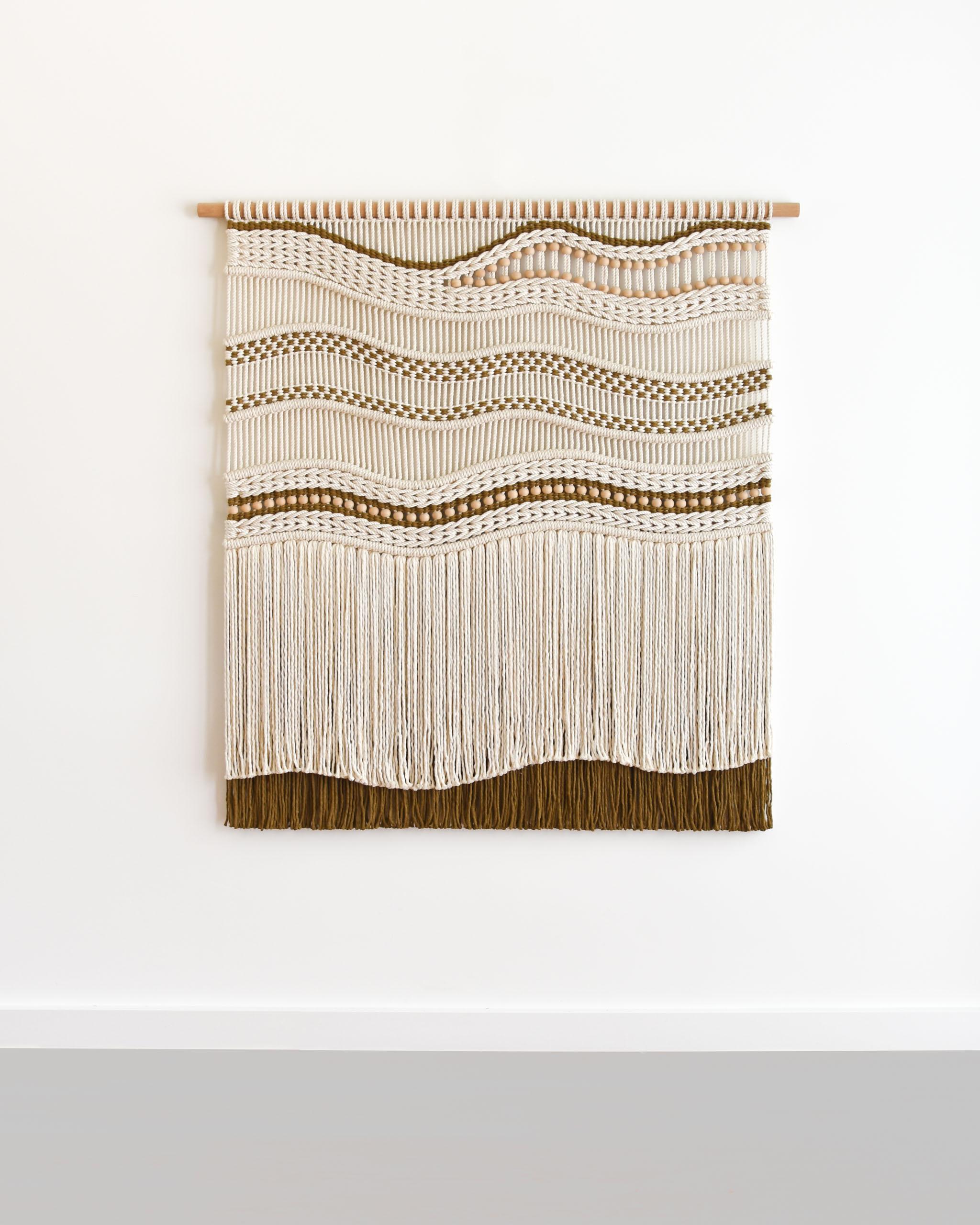 TIDES ist eine Erkundung von Texturen und Farben. Ich habe zwei Techniken kombiniert, Makramee und Weben, um einen Kunstfaserteppich mit interessanten Formen, Mustern und Texturen zu schaffen.

Dieser Wandbehang ist aus ägyptischem Giza-Baumwollseil