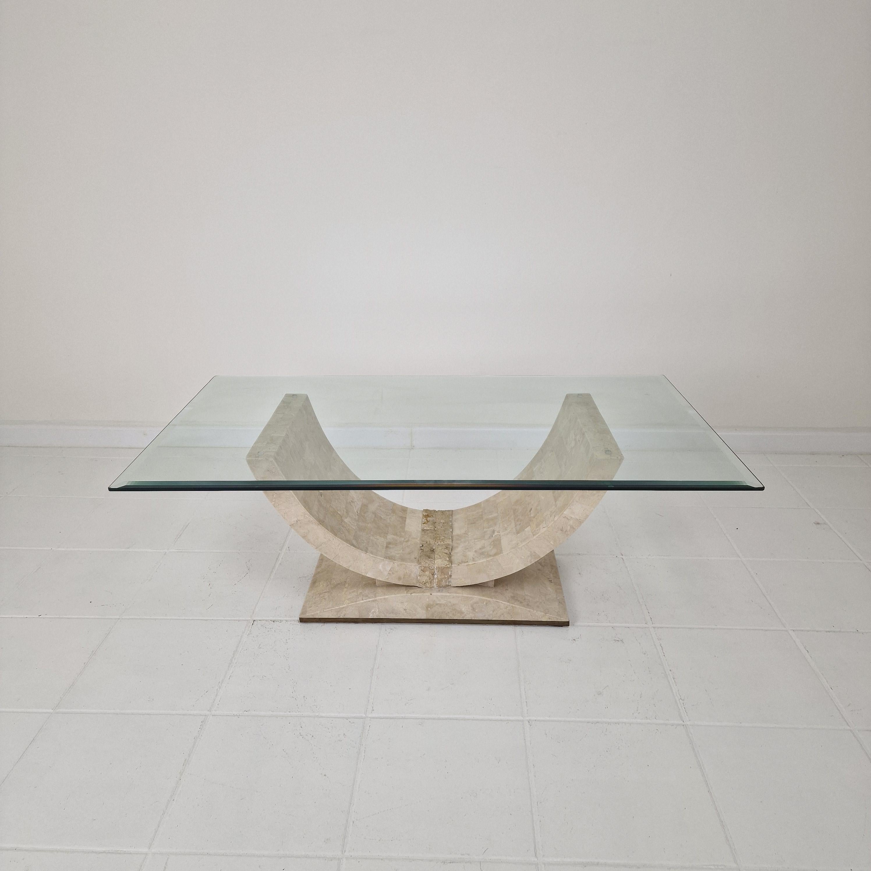 Lovely Postmodern 1990s design coffee or side table, fabricated in Italy.

The base of this cute table is made of rough edged brick motif Mactan stone or Fossil Stone with a nice brass accent.

The facet cut glass plate is in very good condition, no