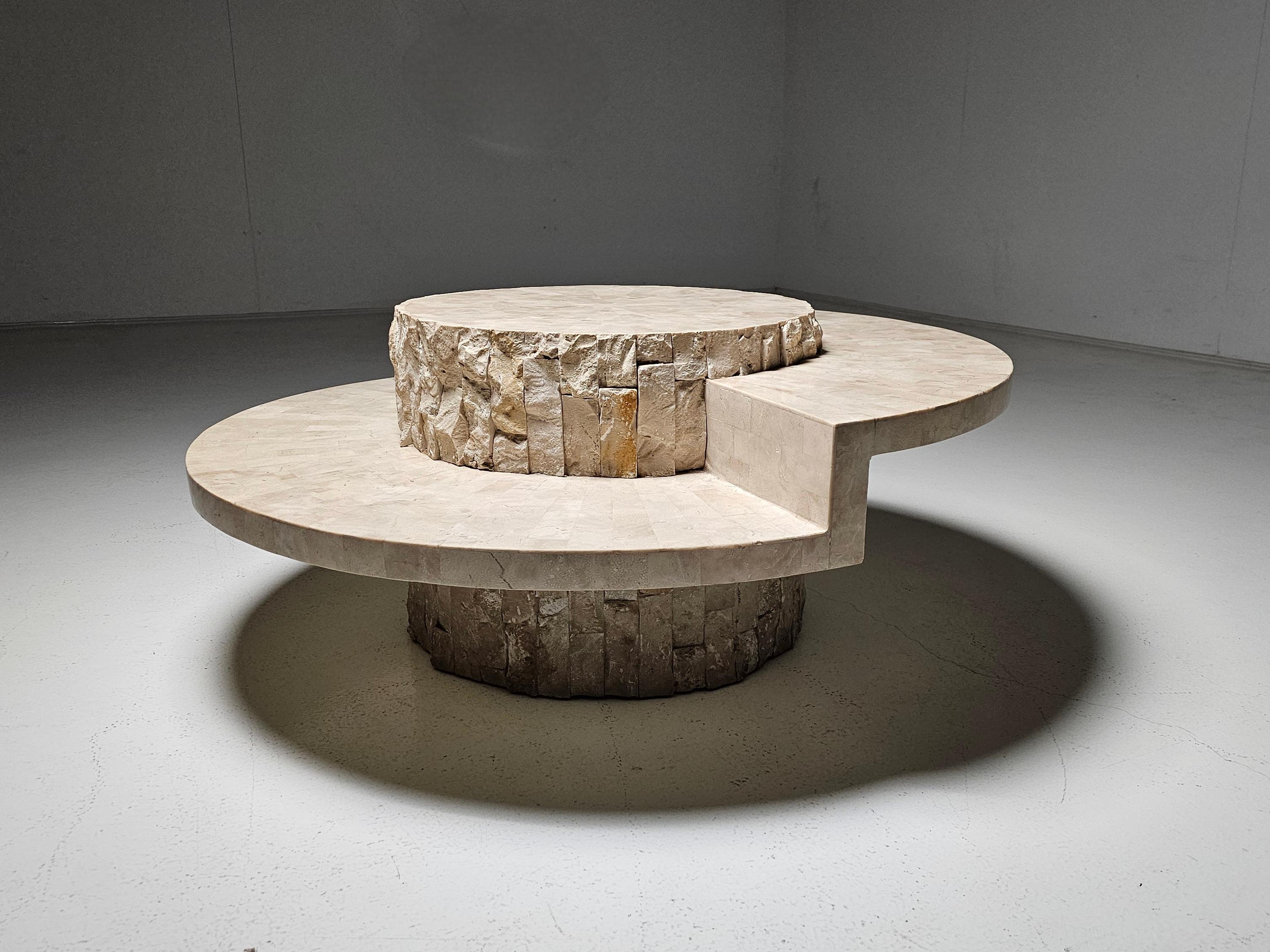 Magnussen Ponte,  Couchtisch aus Mactan-Stein, Belgien, 1980er Jahre.

Eine massive, runde Tischplatte aus sorgfältig ausgewähltem Naturstein, kombiniert mit einer robusten, geschichteten Kante, die den rohen Charakter des Materials offenbart.