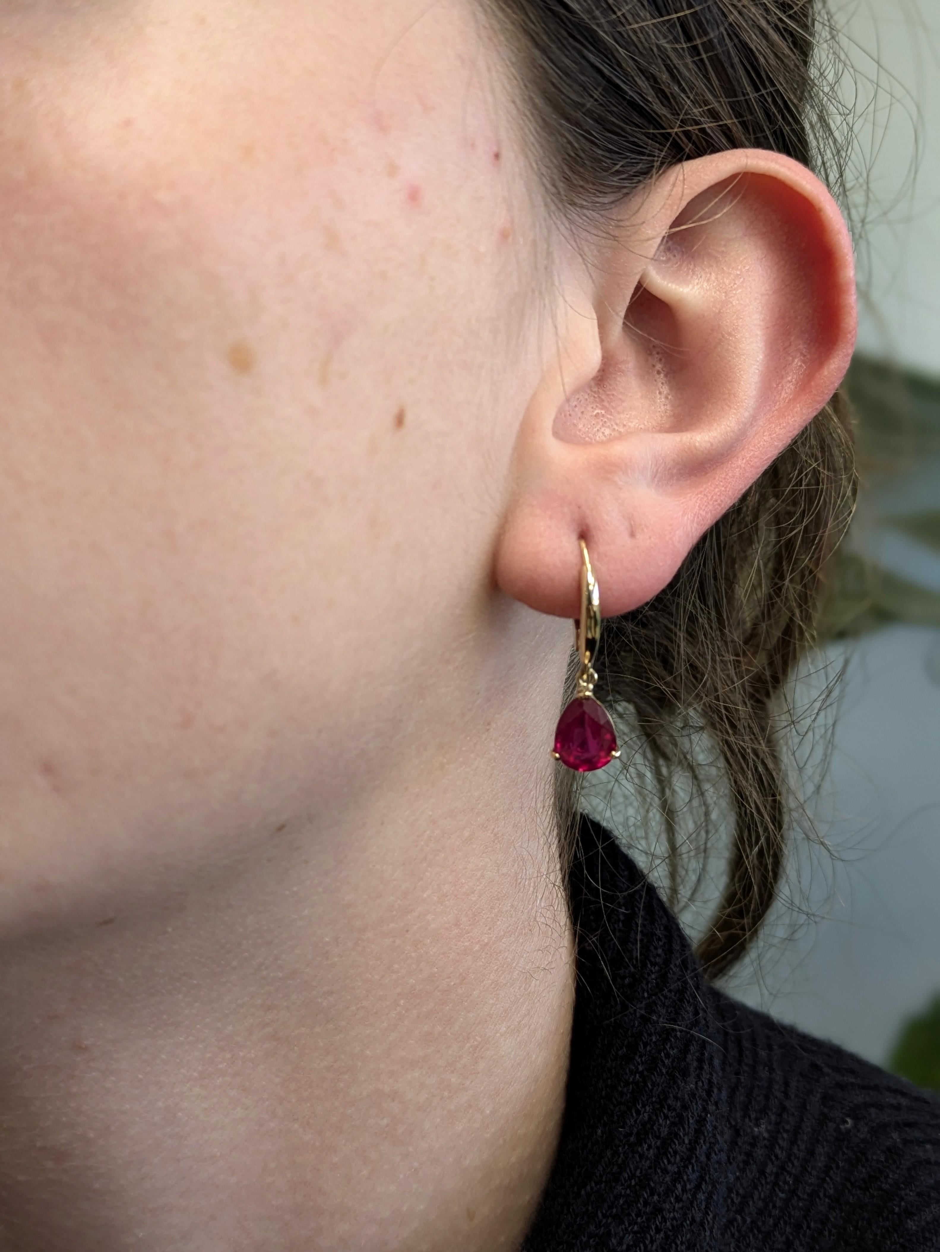 Realizzati in elegante oro 14k (1,3 g), questi splendidi orecchini presentano vibranti rubini del Madagascar a forma di pera per un totale di 4,49 carati. Ogni pietra centrale di 9x7 mm mostra la ricca tonalità rosso fuoco per cui i rubini del