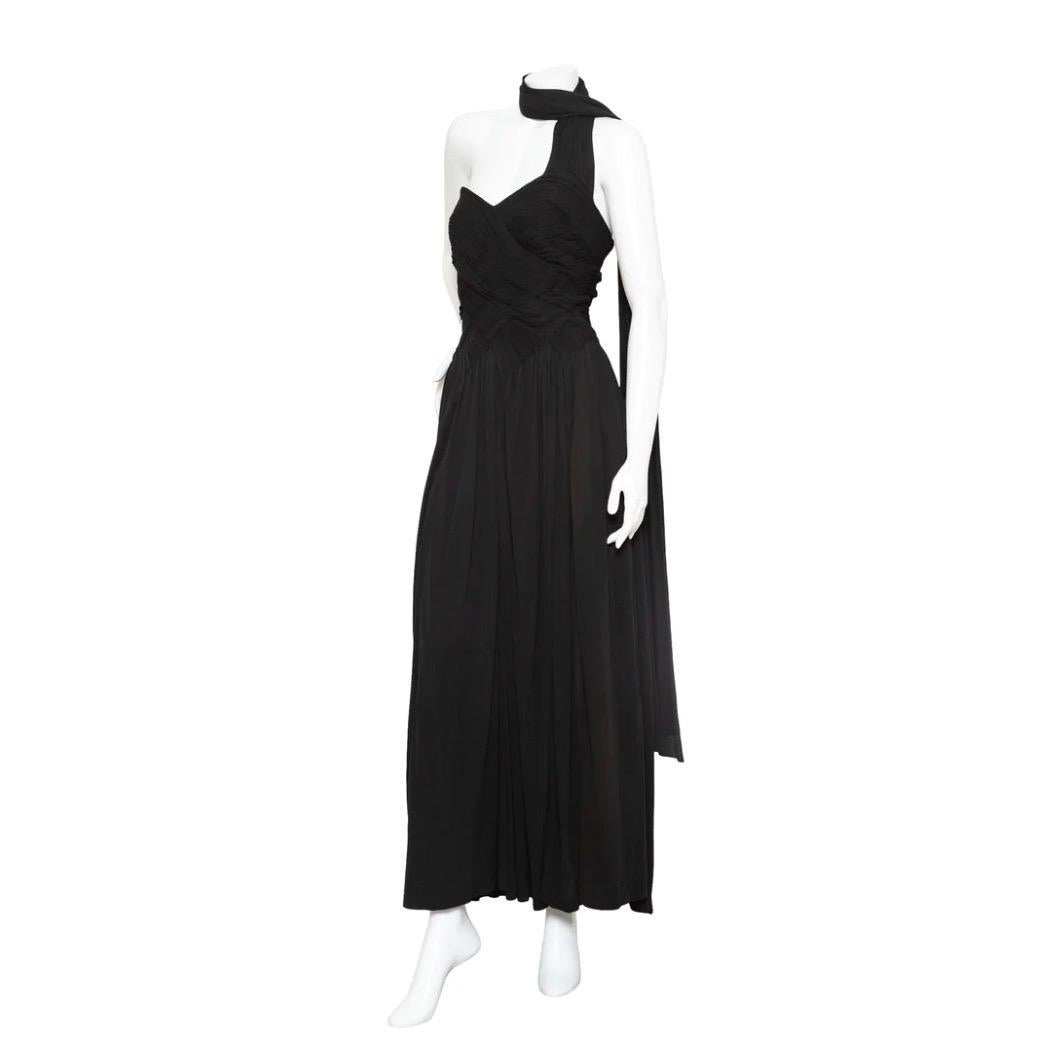 Madame Grès 1960s Black Sleeveless Scarf Dress

Vintage; circa 1960s
Black
Sleeveless
Wraparound scarf extending from left side
Sweetheart neckline 
Pleated bodice woven to form 
Gathered waistband
Back zipper closure
Has lining
Made in France
No