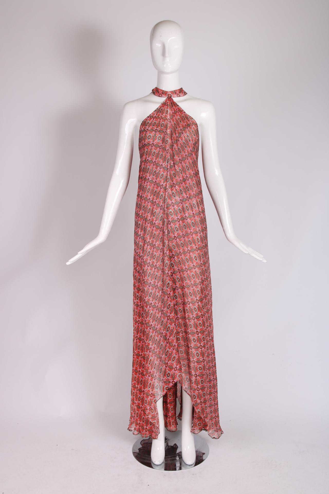 A Madame Gres boutique printed chiffon halter neck gown with an unusual draped design at the back. The hemline is higher at each side and longer in the front and back. Size tag 40. In excellent condition.

Bust: approx. 34