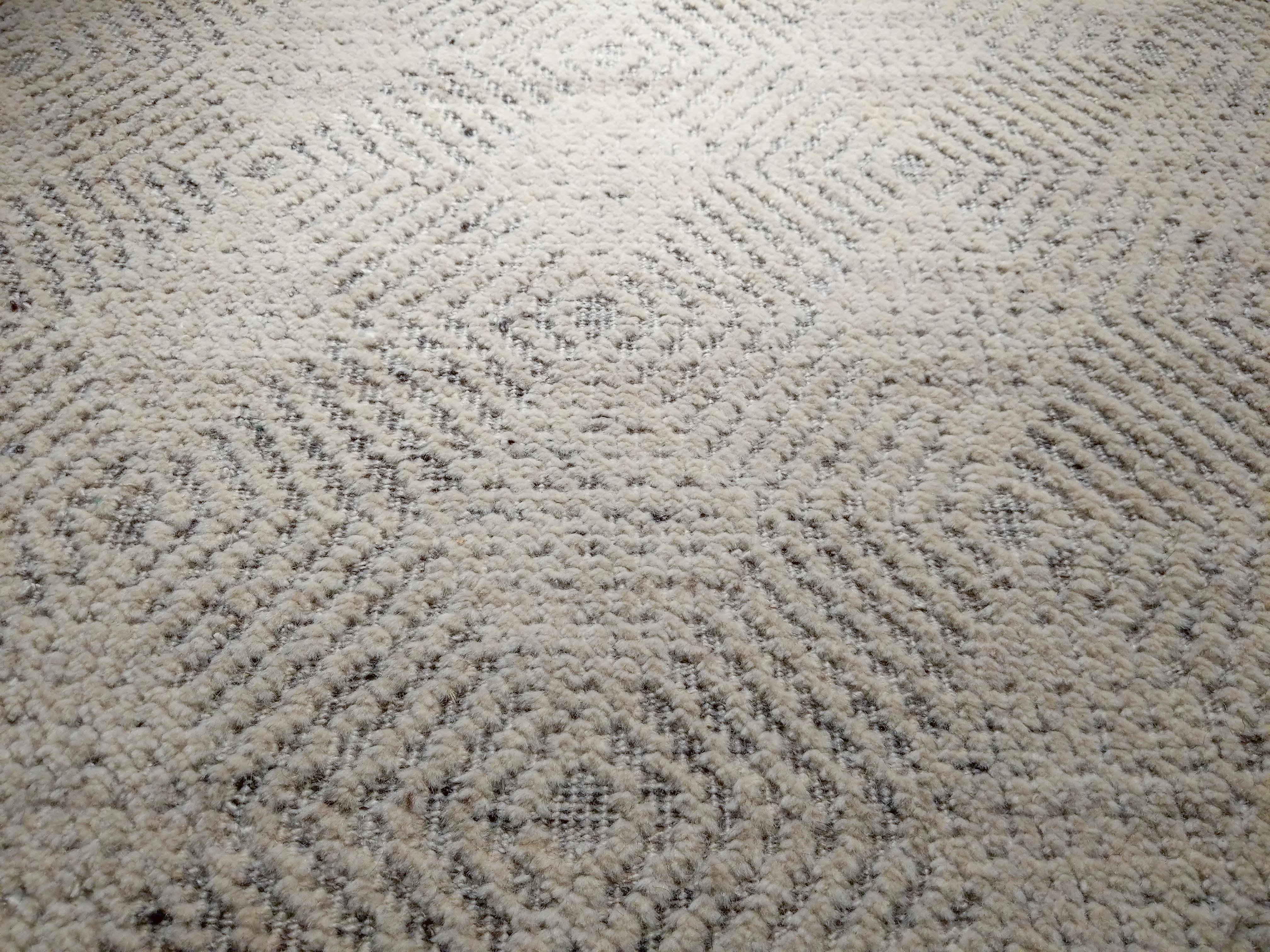Inspired by the traditional rugs from the Island of Sardinia, Maddalena is hand knotted in pure wool and distinguished by an all-over pattern of ivory lozenges on a high-low textured background in ivory and light grey. The resulting palette makes it