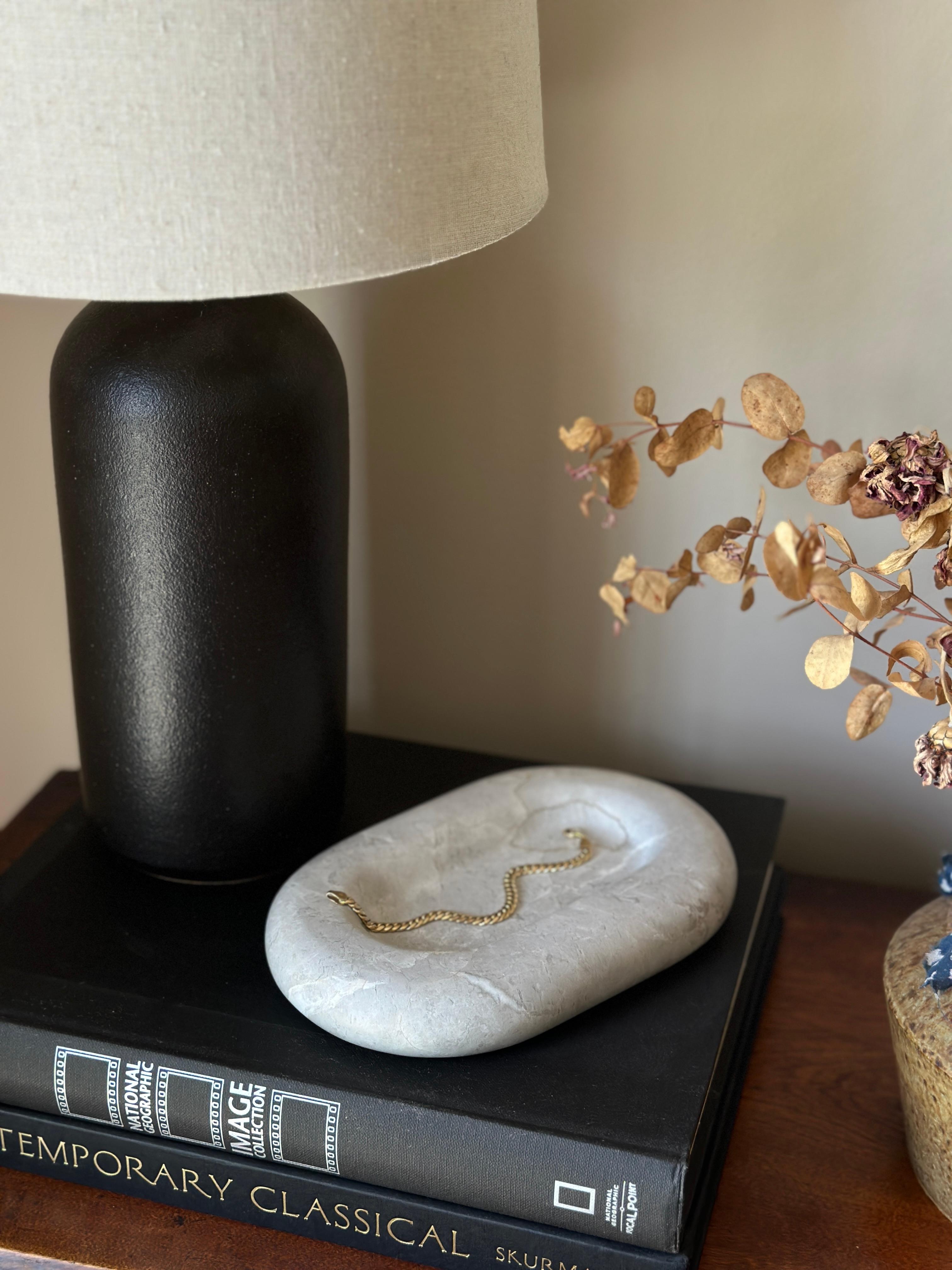 A limited production, functional object d'art exclusively produced by Anastasio Home. The Maddi is a chunky, six-inch oval catchall cut from a single piece of solid marble or stone with a large, playfully modern “puffed” border, hand-finished by