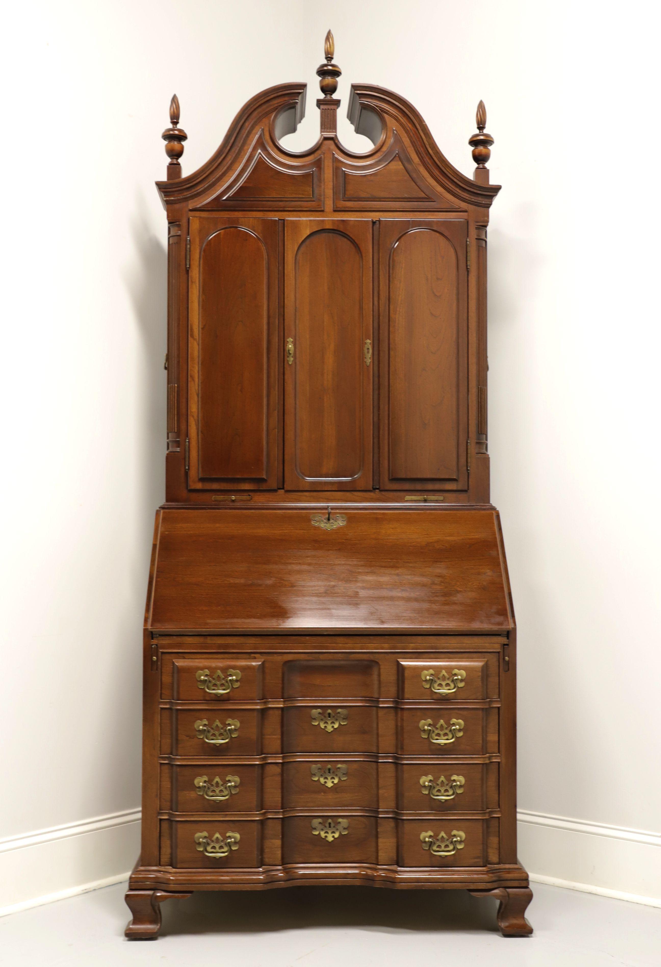 A Chippendale style licensed reproduction by Maddox Furniture of an 18th Century Secretary Desk created by Goddard Townsend of Newport, Rhode Island. Solid cherry with brass hardware, pediment top with three finials and ogee bracket feet. Upper