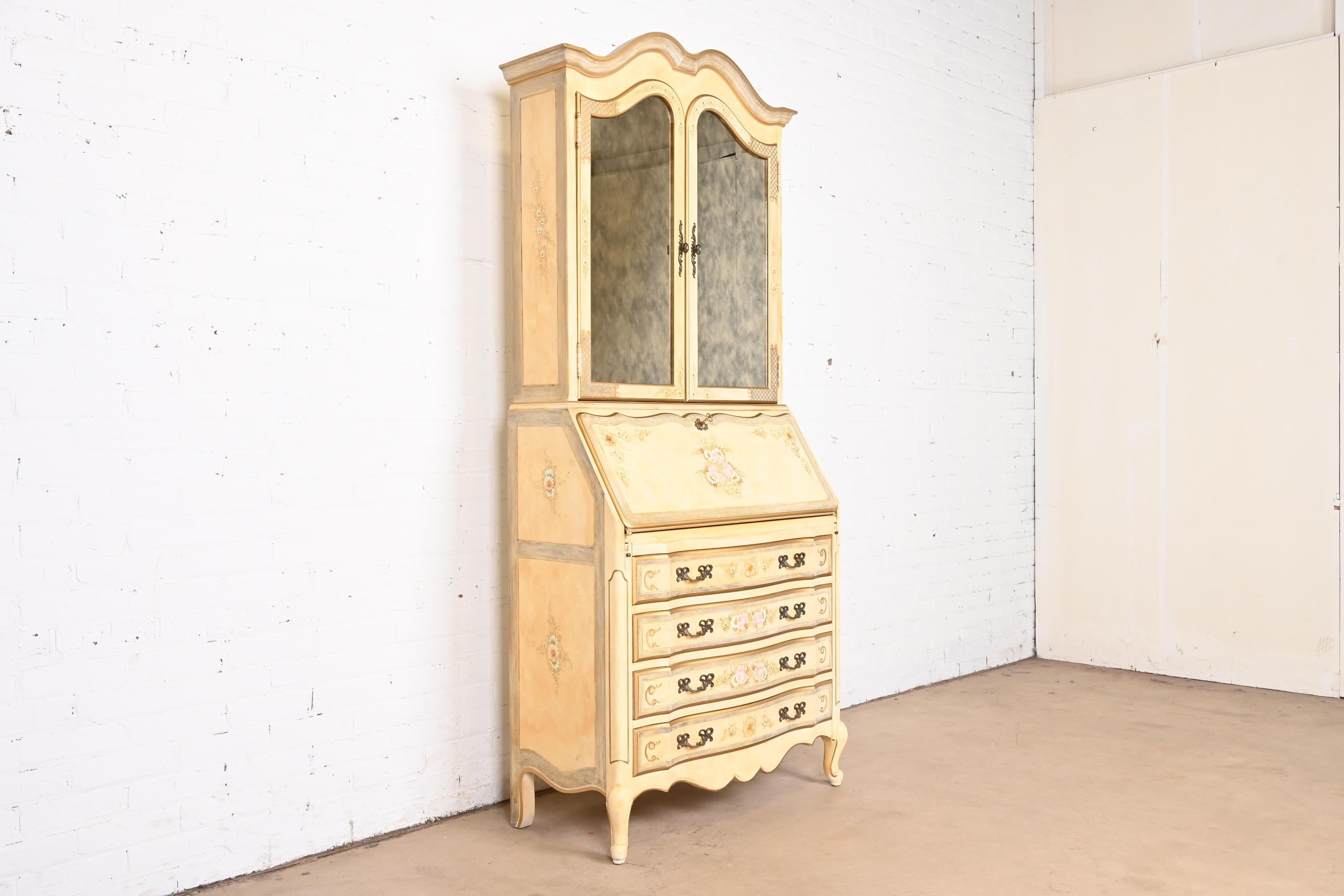 A gorgeous French Provincial Louis XV style bureau with drop front secretary desk and mirrored bookcase hutch top

By Maddox Furniture

USA, 1970s

Cream lacquered walnut, with hand-painted floral details, mirrored glass doors, and original brass