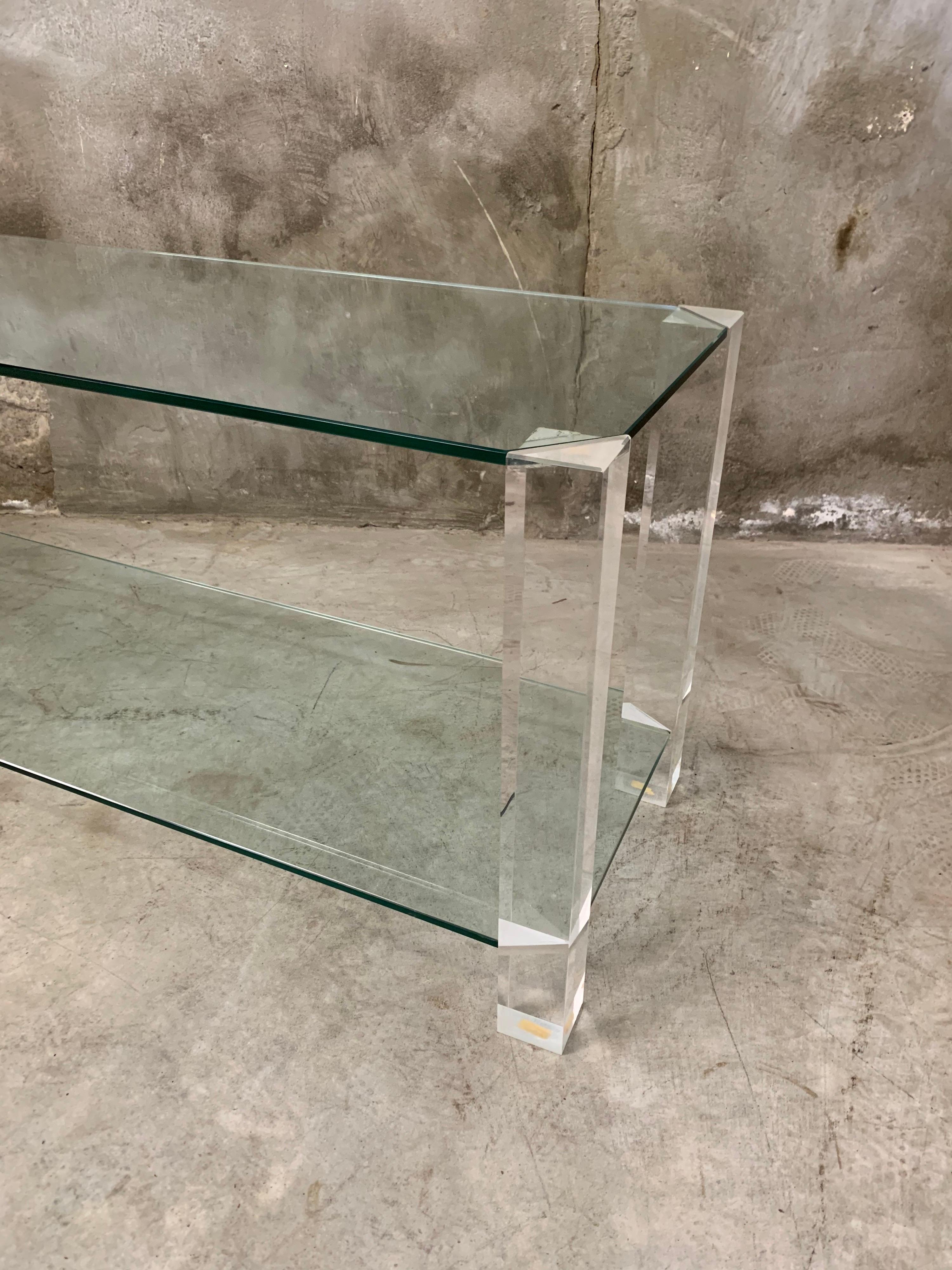 Made in Italy, by Raventos 70s / 80s during the Hollywood Regency revival. Thick plexiglass legs with recessed glass shelves (fixed). Cool as a side table as a coffee table or, for example, as a TV furniture. super chic! Condition is still very