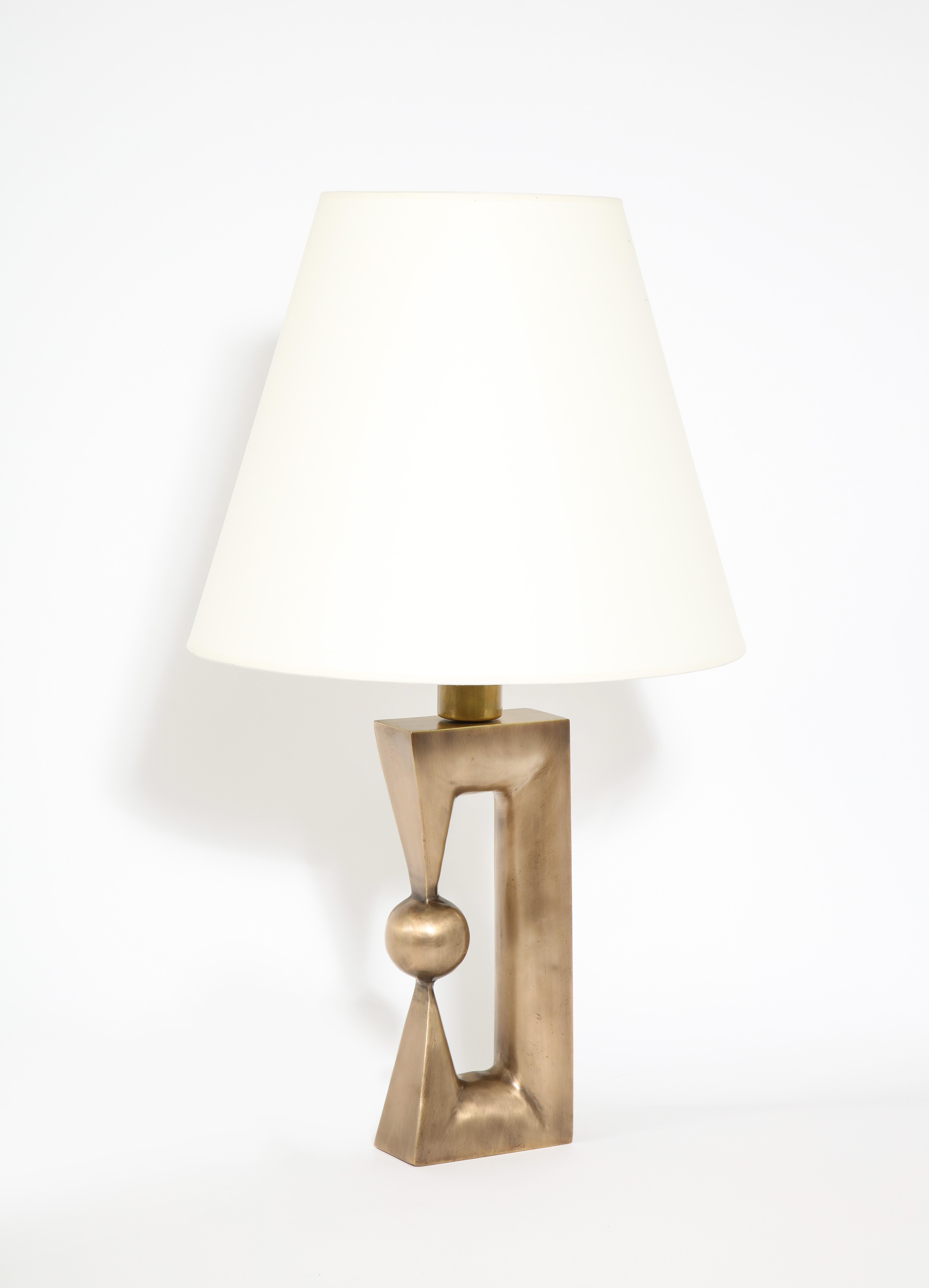 Une lampe de table en bronze fabriquée sur commande et inspirée d'une sculpture de Noguchi. Ces lampes sont fabriquées aux États-Unis et sont disponibles dans un large éventail de finitions personnalisées.

Dimensions de la base seulement : 6'' x 3