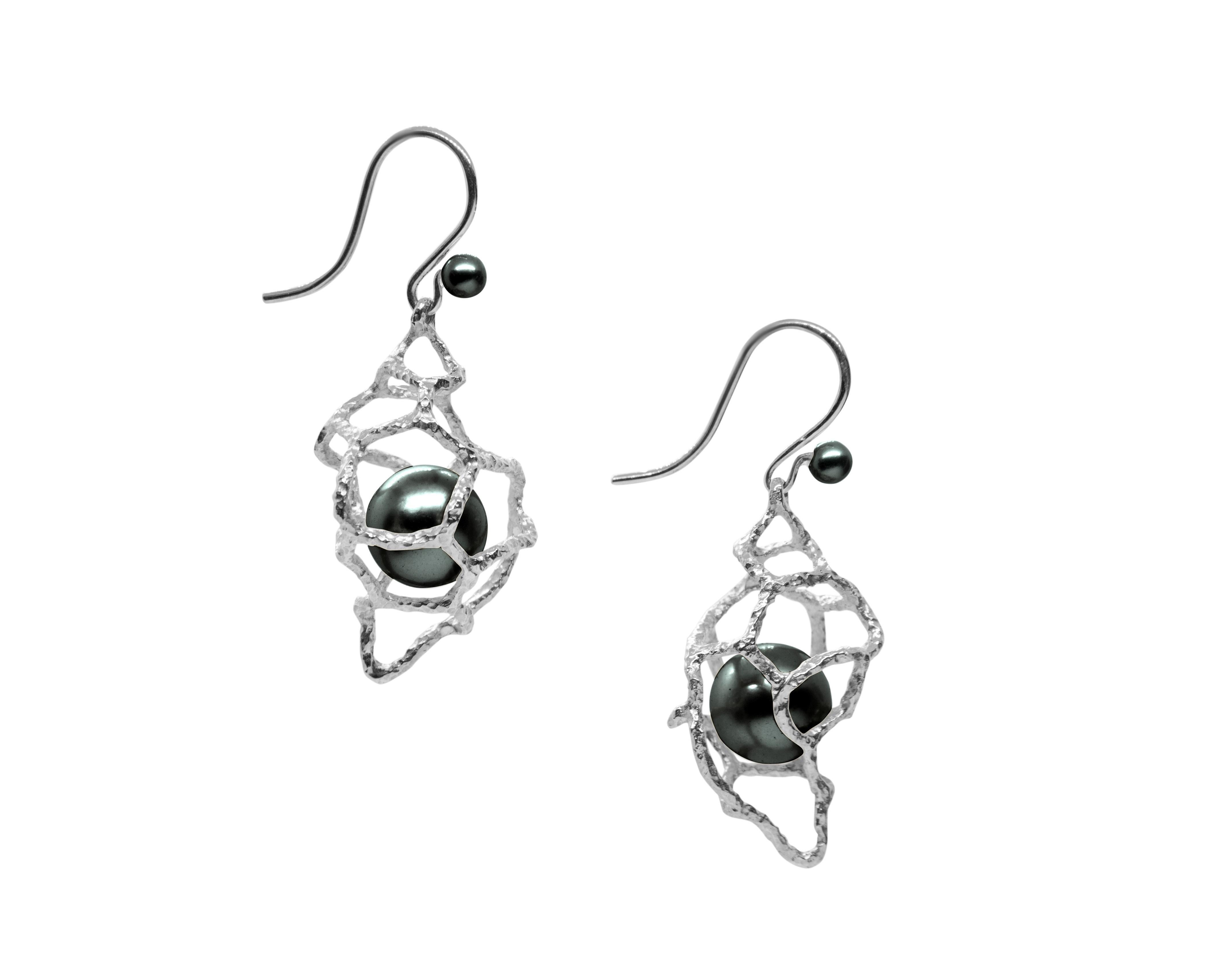 This pair of earrings are from Lingjun's 'FISSURE' collection, inspired by the conch shell in the sea, embracing the fine round black Tahitian pearls, celebrating the vibrant life of our oceans.

The organic lines of gold were hand carved to mimic