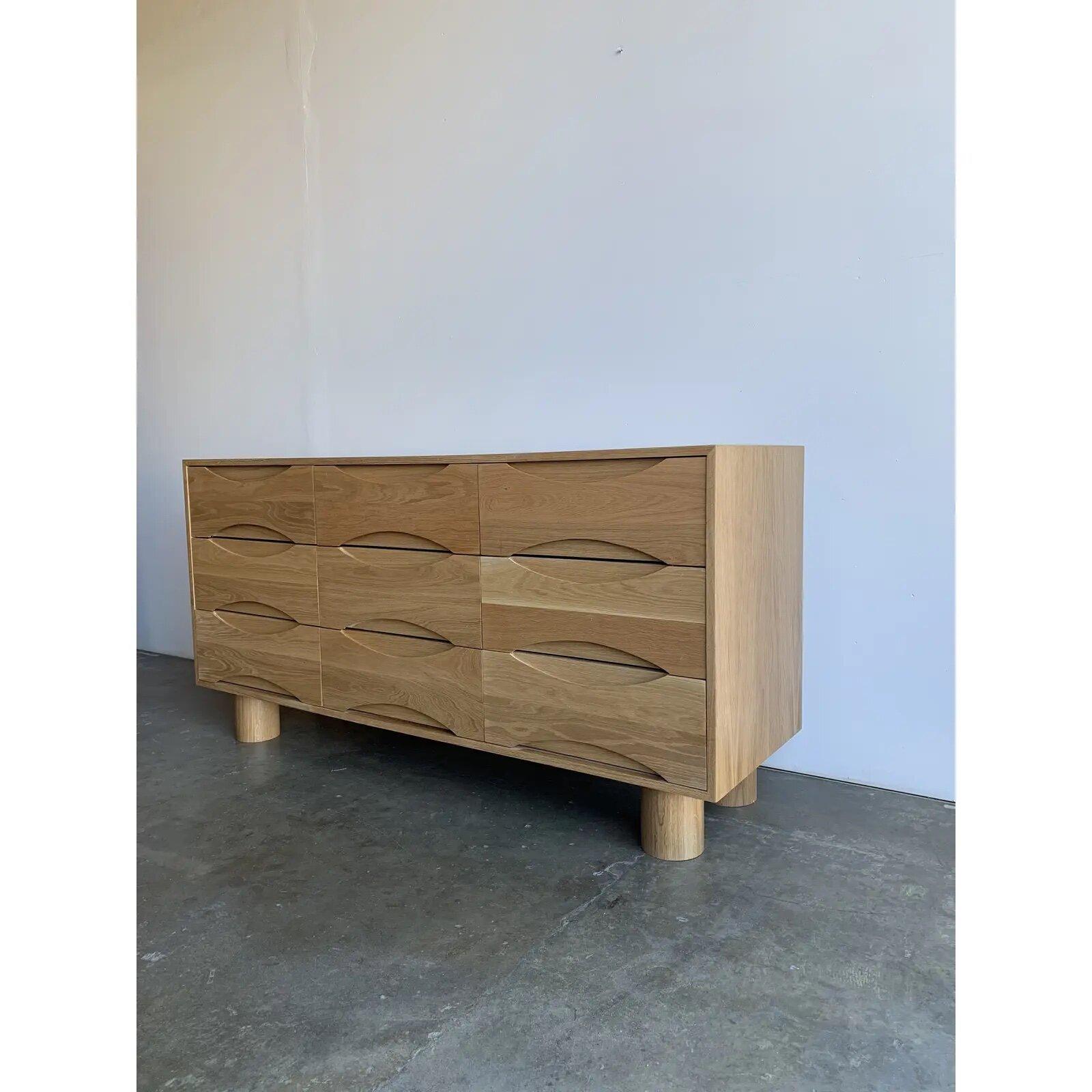 Handcrafted in house the “ojitos “ dresser is made from solid and veneered whtie oak with solid turned thick Cyclinder legs. All twelve drawers featured sculpted handles. Item sits on four solid white oak cinder legs and is completely sealed with a