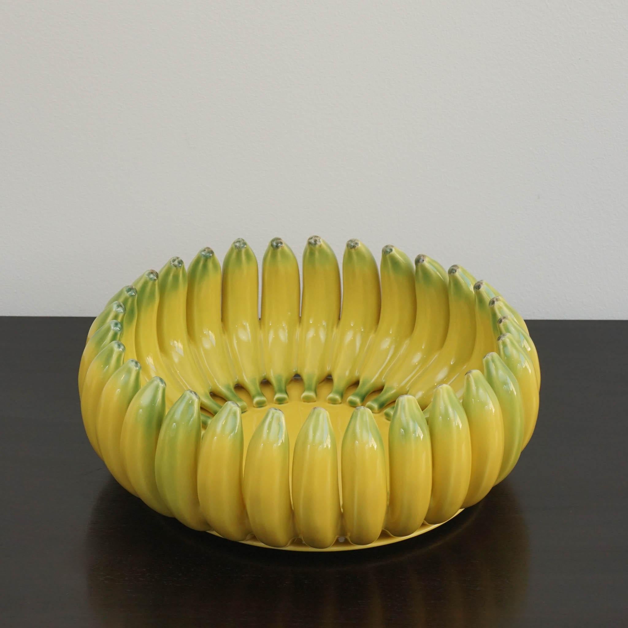 Mettez votre table dans un style tropical amusant avec ce centre de table décoré de bananes de Bordallo Pinheiro. Fabriqué en faïence, ce centre de table présente un motif de banane. Il apportera à coup sûr une touche unique à votre table et sera