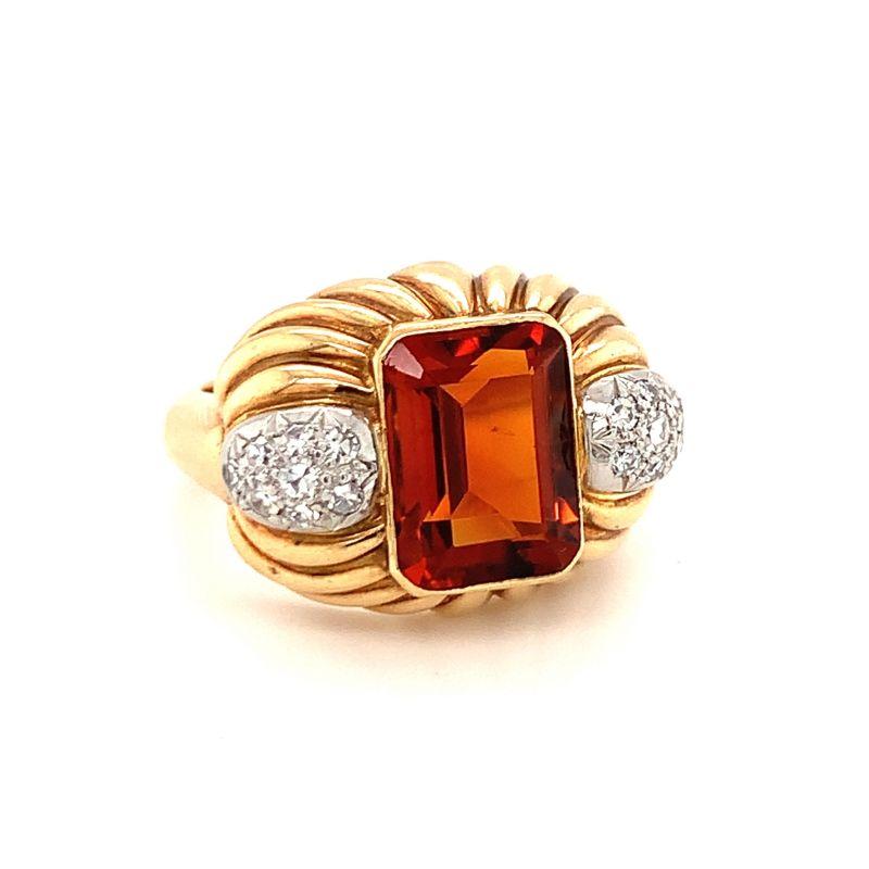 Deep fiery-orange Madeira citrine weighing 6 ct. bezel set within 18K yellow gold and flanked by 16 single cut diamonds totaling 0.45 ct. Intricate fluted gold mount design. 

Ornate, eye-catching, vibrant.

Additional information:
Metal: 18K yellow
