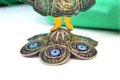 Venditrice di fiori di Madeira in filigrana smaltata su una base con cerchi