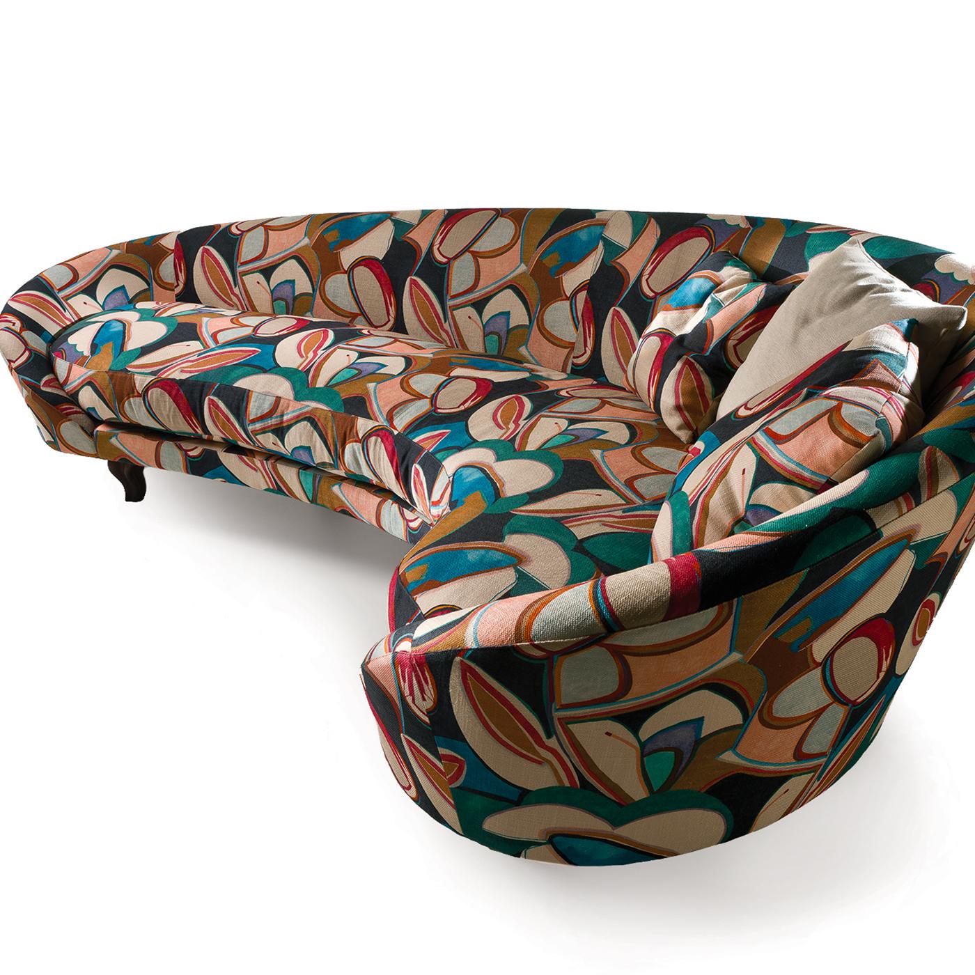 Upholstered with a printed fabric whose colorful and abstract pattern evokes the lively charm of the 1970s, this stunning sofa boasts a unique silhouette to match any decor. Its frame creates a curve along which the height of the backrest increases
