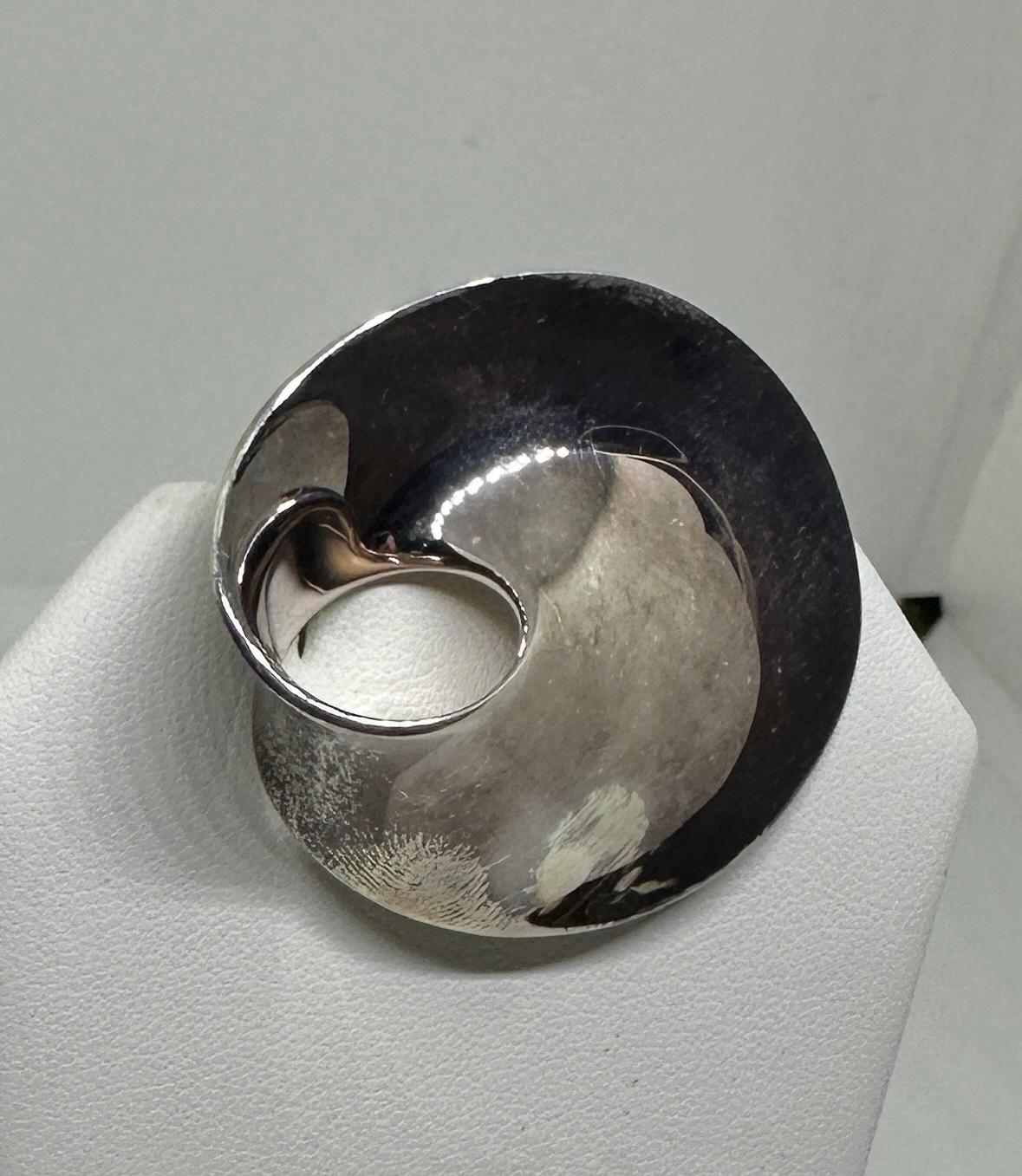 Gönnen Sie sich ein Stück amerikanische und europäische Geschichte mit Madeleine Albrights  ikonische Georg Jensen Pin-Brosche #374B Möbius, entworfen von Vivianna Torun Bülow.  Hier haben wir die Kombination einer der wichtigsten Persönlichkeiten