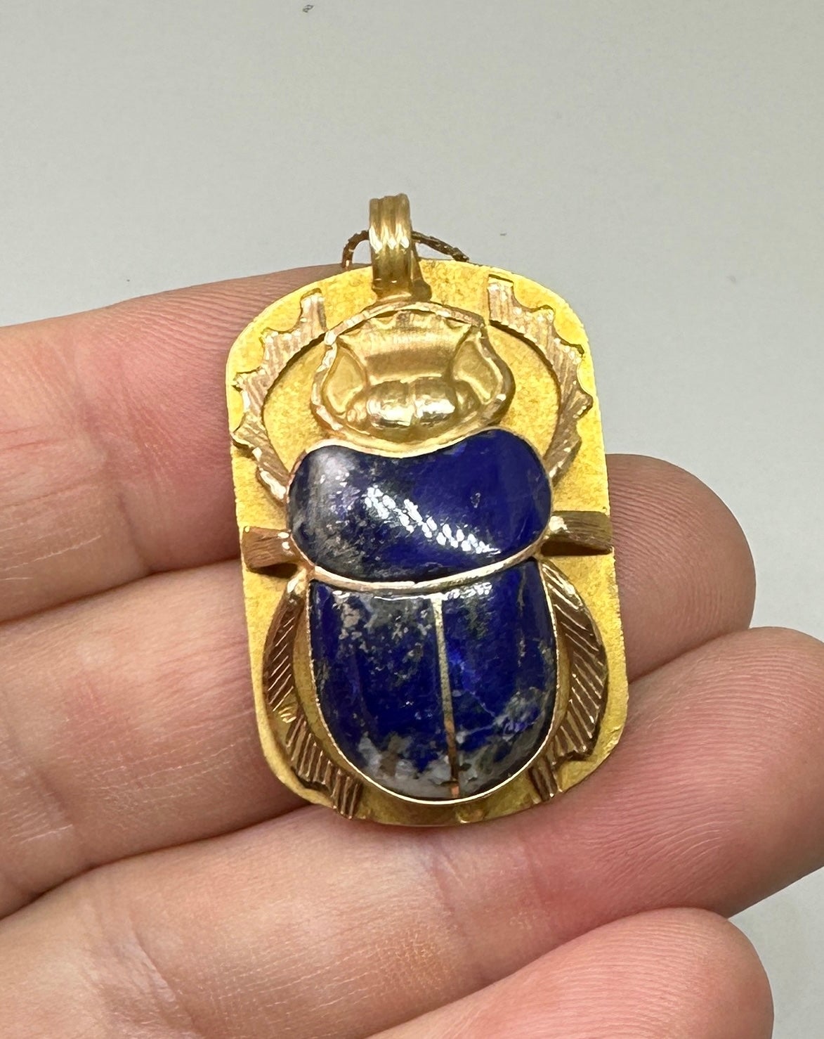 Indulge in a piece of American History with Madeleine Albright's extraordinary monumental Egyptian Revival Scarab Insect Pendant Necklace with Egyptian Hieroglyphics in solid 18 Karat Gold and Lapis Lazuli, along with a copy of her book, 