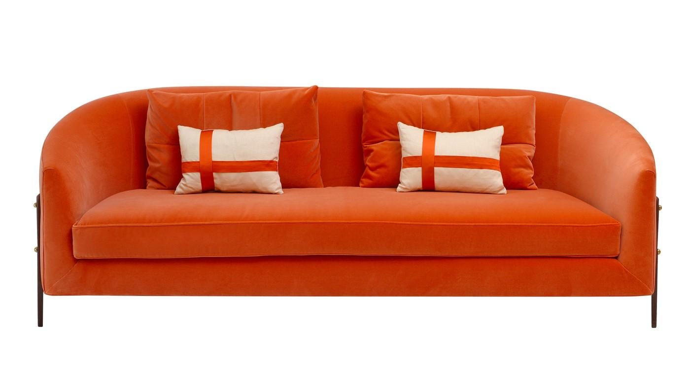 This charming sofa boasts a unique character with an inviting silhouette and vibrant orange fixed upholstery. The structure combines solid wood and plywood that rests on thin legs and is padded with memory foam and multi-density polyurethane foam