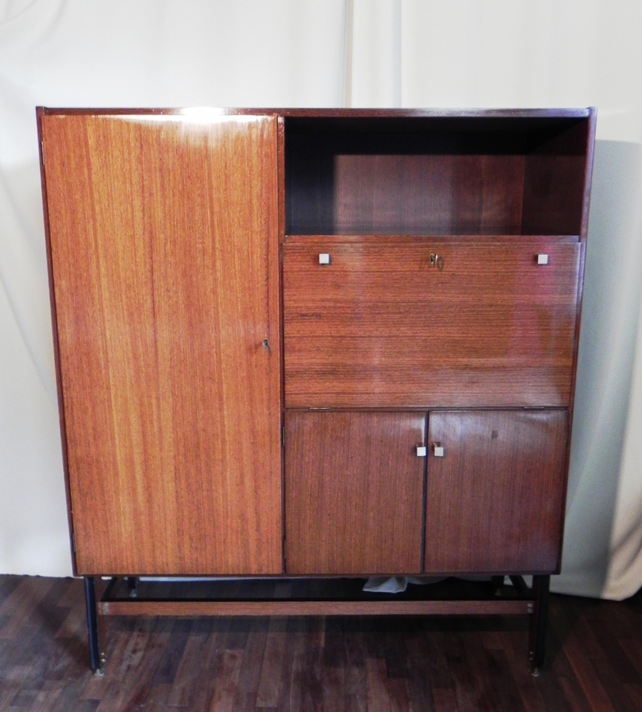 madia anni '50. contenitore con ribalta bar. risale alla fine degli anni '50. tutto impiallacciato in legno teak. molto interessanti i piedini in ottone fissati con vitone trasversali in ottone. il piede ha una bella modanatura frontale. le