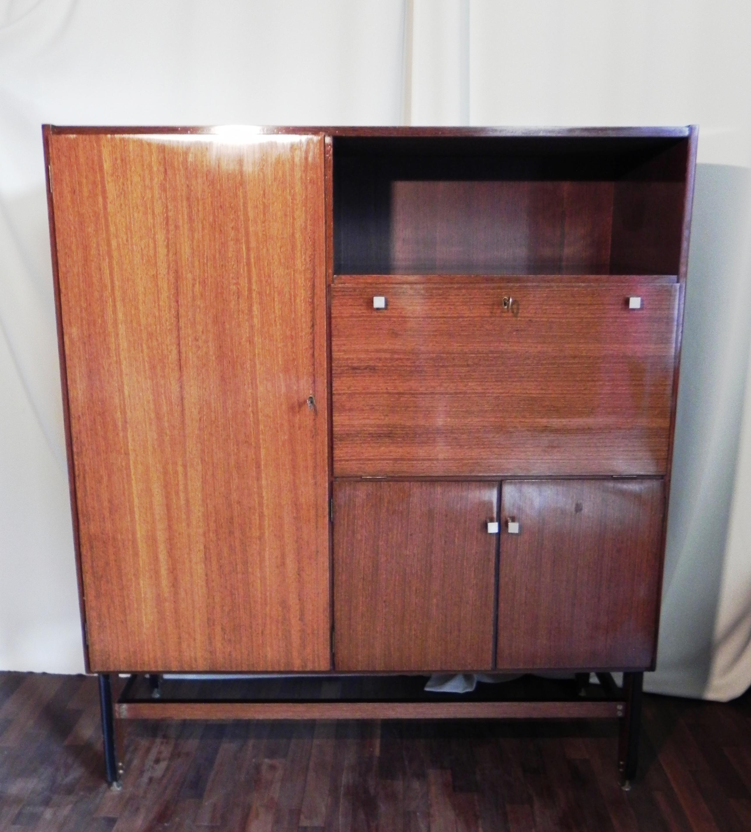 1950s sideboard. storage unit with bar flap. dates from the late 1950s. all teak wood veneer. very interesting brass feet attached with brass cross screw. foot has beautiful front molding. condition of cabinet is good, has some flaws in the