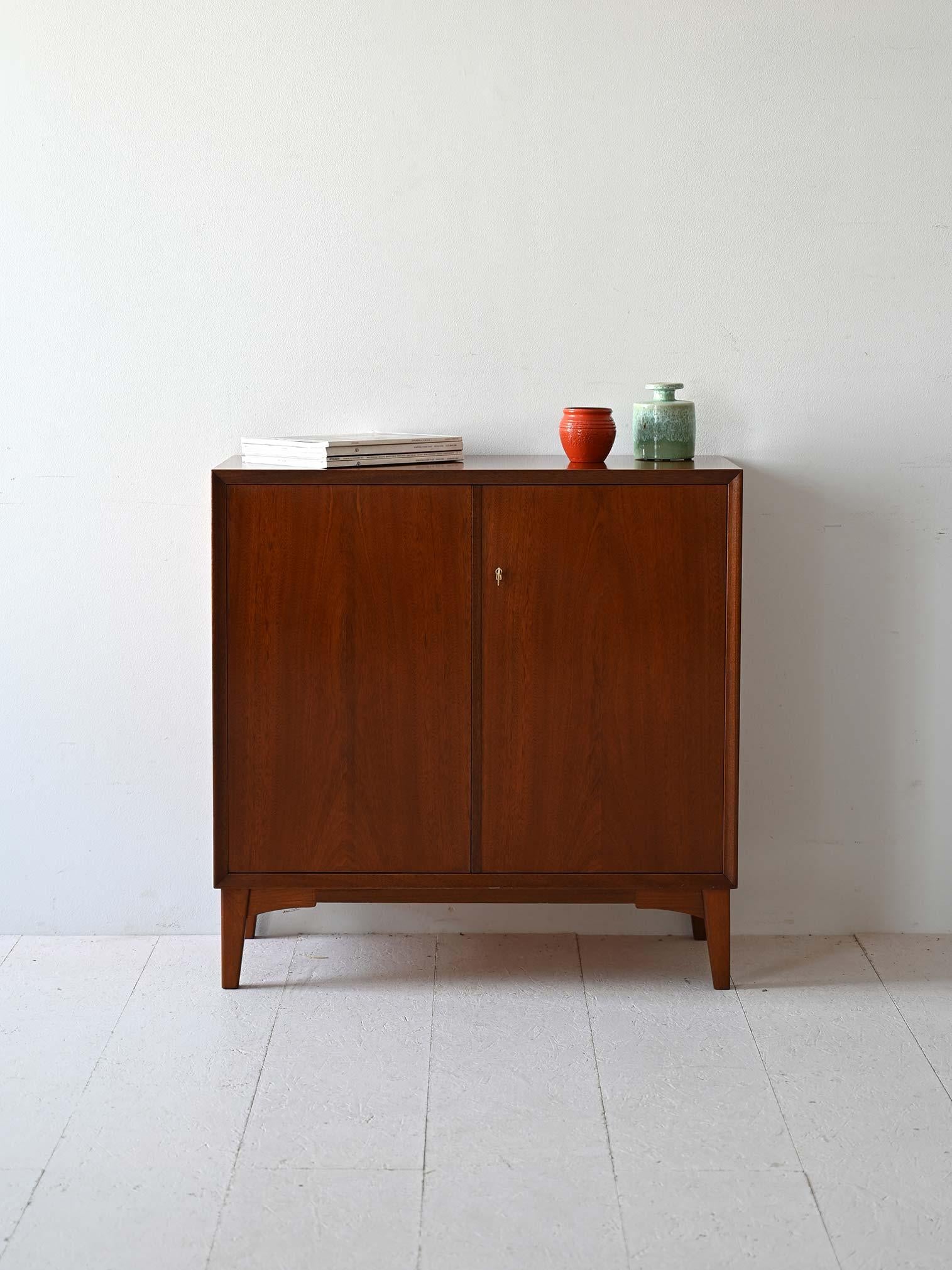 Vintage 1960s sideboard with hinged doors. Inside, the space is divided with three shelves. 

A functional and diemnsionsome piece of modernism. Useful both as a kitchen sideboard and as a storage cabinet or bookcase. 
Good conditions. Potrebbe
