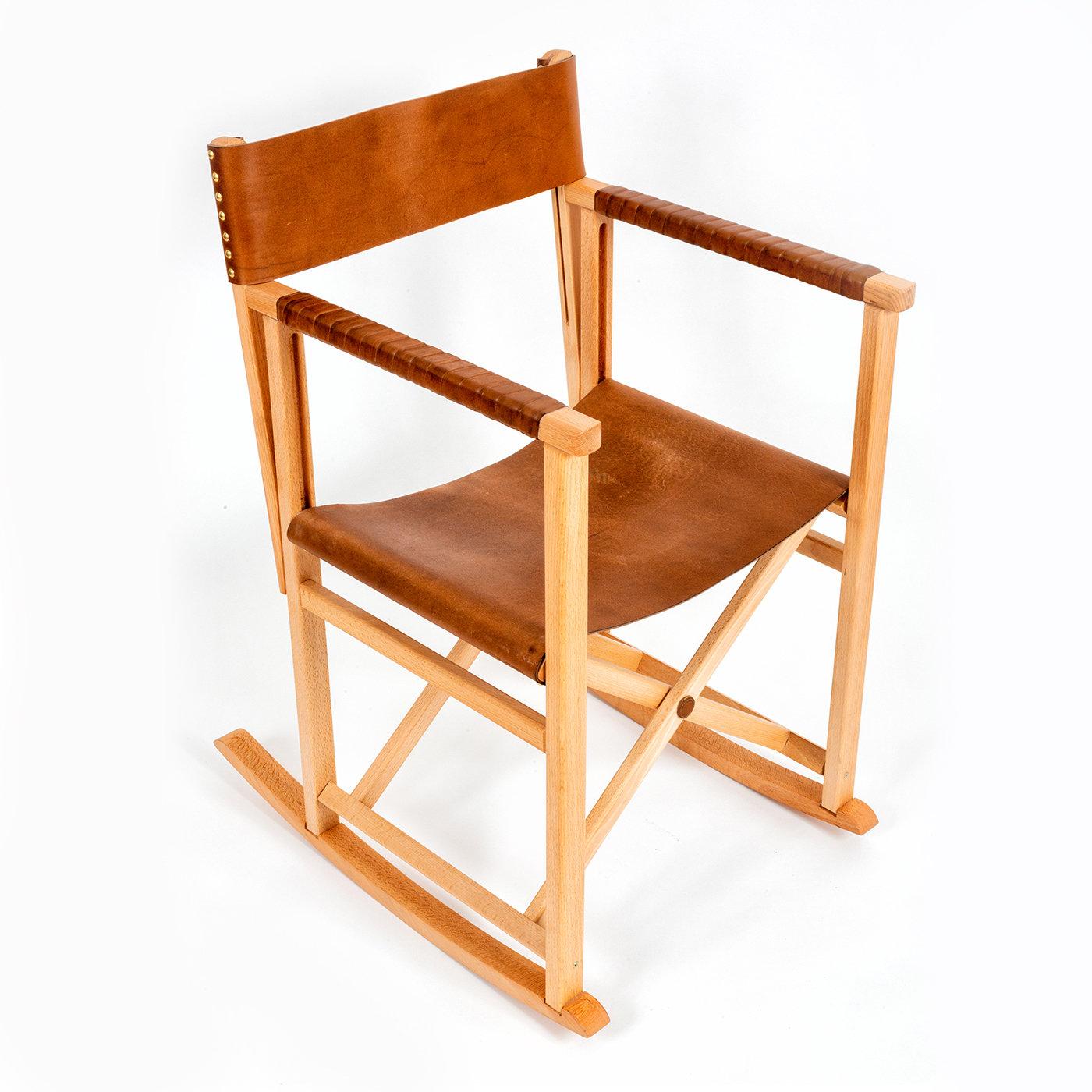 Exemple magistral de design élégant et polyvalent, ce fauteuil à bascule présente une structure robuste en bois de chêne avec un dossier et une assise (H 48 cm) en cuir précieux, qui recouvre également les accoudoirs linéaires pour offrir un confort