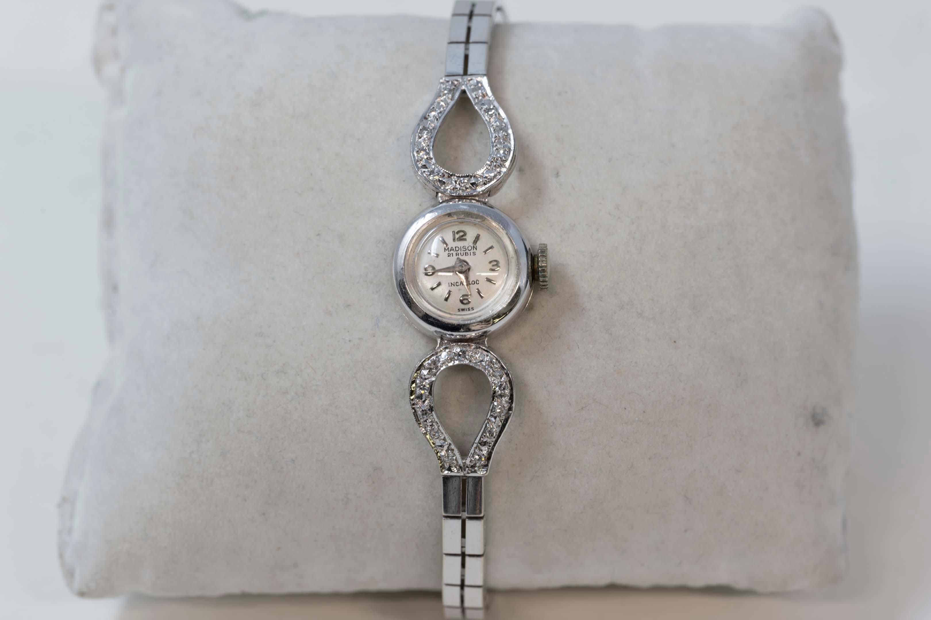 14kt white gold and 22 diamond single cut of .02ct each ladies Madison mechanical watch. Will fit to a 6 3/4 inches wrist. In good working order stamped on the back and on the clasp. Made in Switzerland. 
