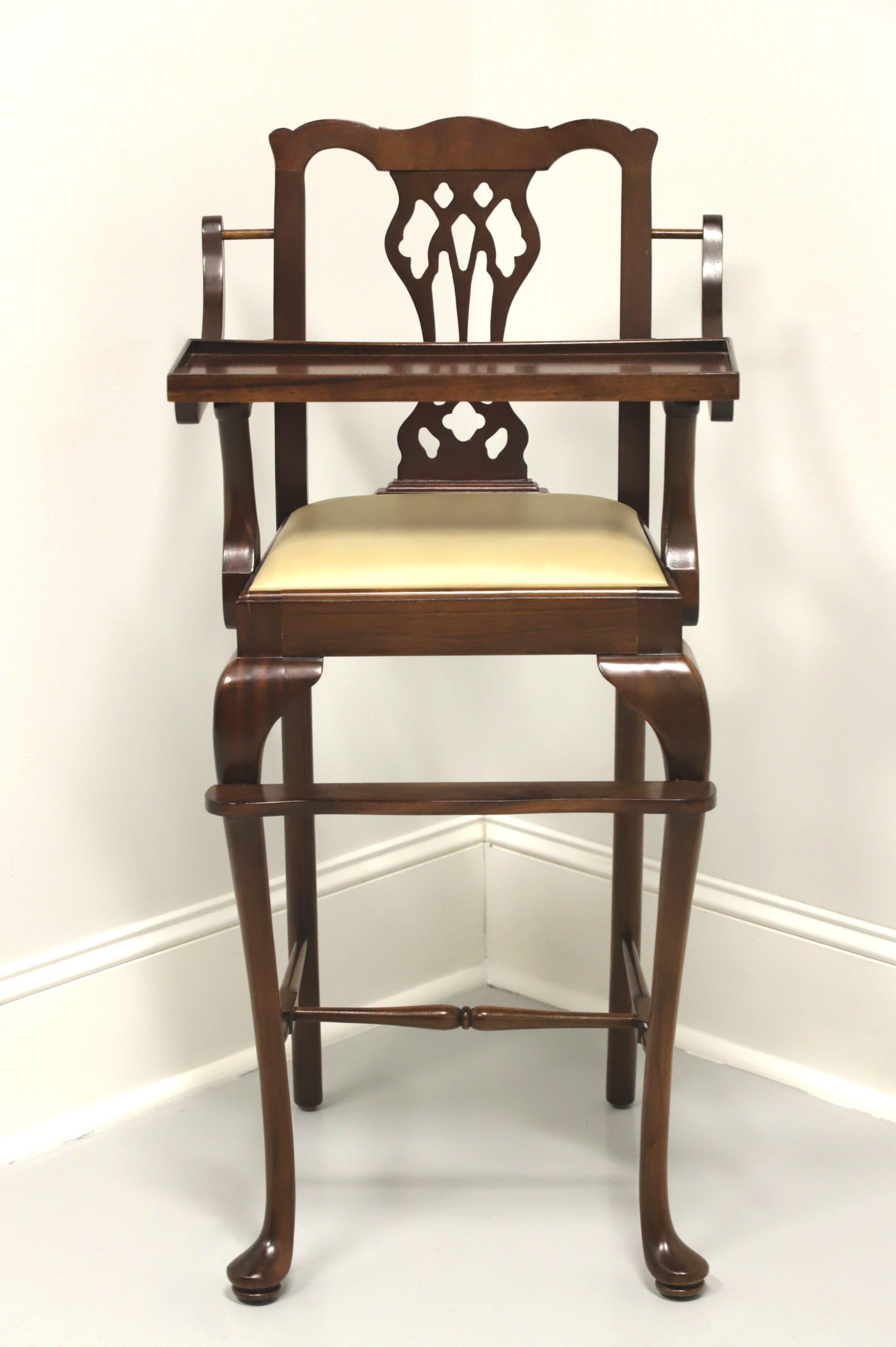 A Queen Anne style child's high chair by Madison Square, of Hanover, Pennsylvania, USA. Solid mahogany with carvied crestrail & backrest, removable fold-up tray, vinyl upholstered seat, foot rest, cabriole legs, stretchers and pad feet. Made in the