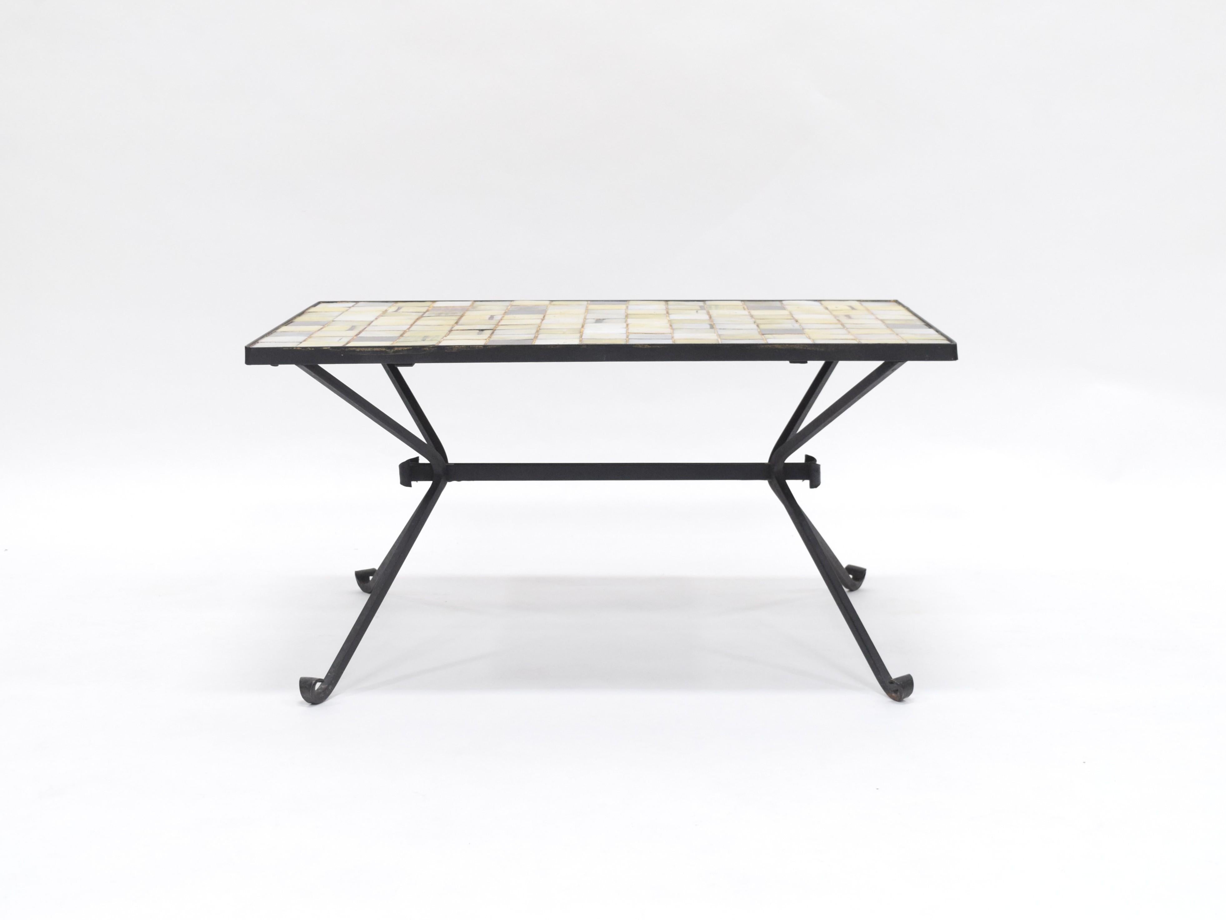 Esta mesa Mado Jolain combina el arte de la cerámica hecha a mano con el refinado trabajo del metal, dando como resultado una pieza funcional y profundamente expresiva. 
La superficie cerámica presenta una composición modular y cada baldosa está