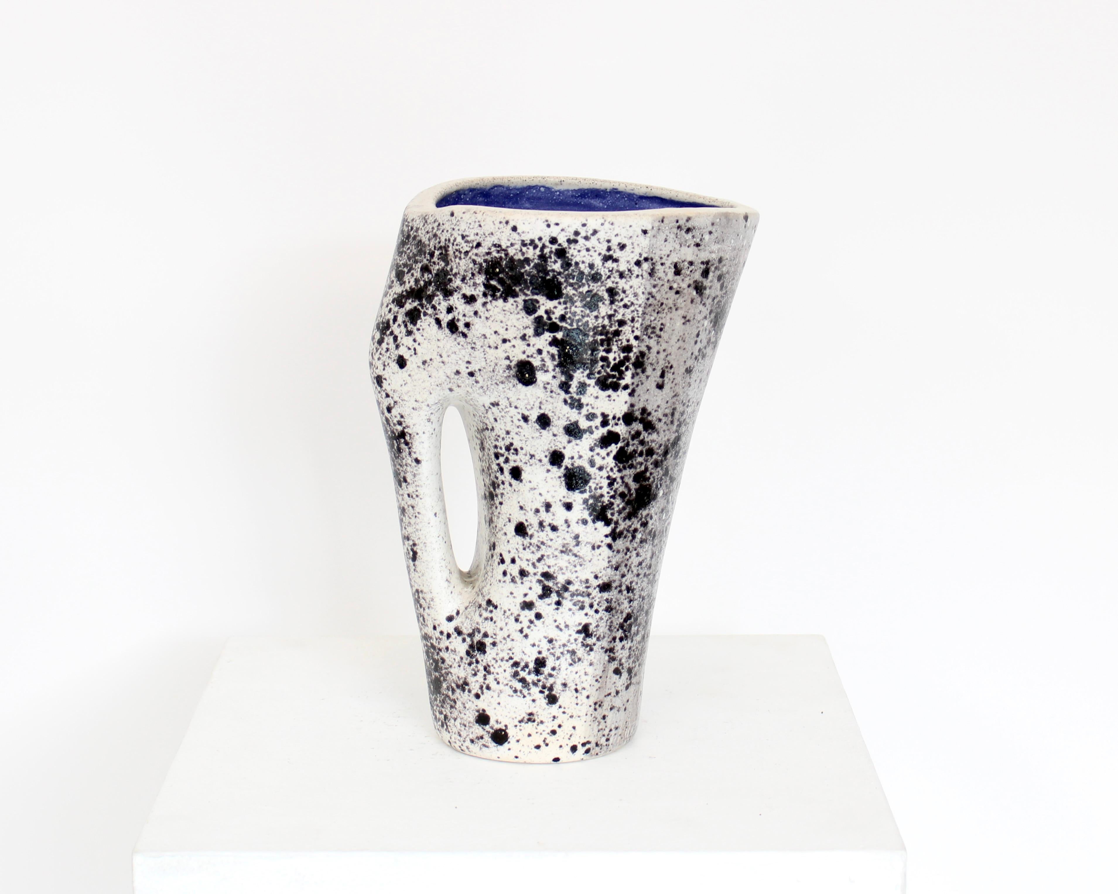 Mado Jolain 1921-2019 ceramic vase with black and gray spatter abstract expressionist glaze application on each surface and intense blue interior. With handle. Signed MJ.
Iconic abstract drawings and forms of the French ceramic artist Mado