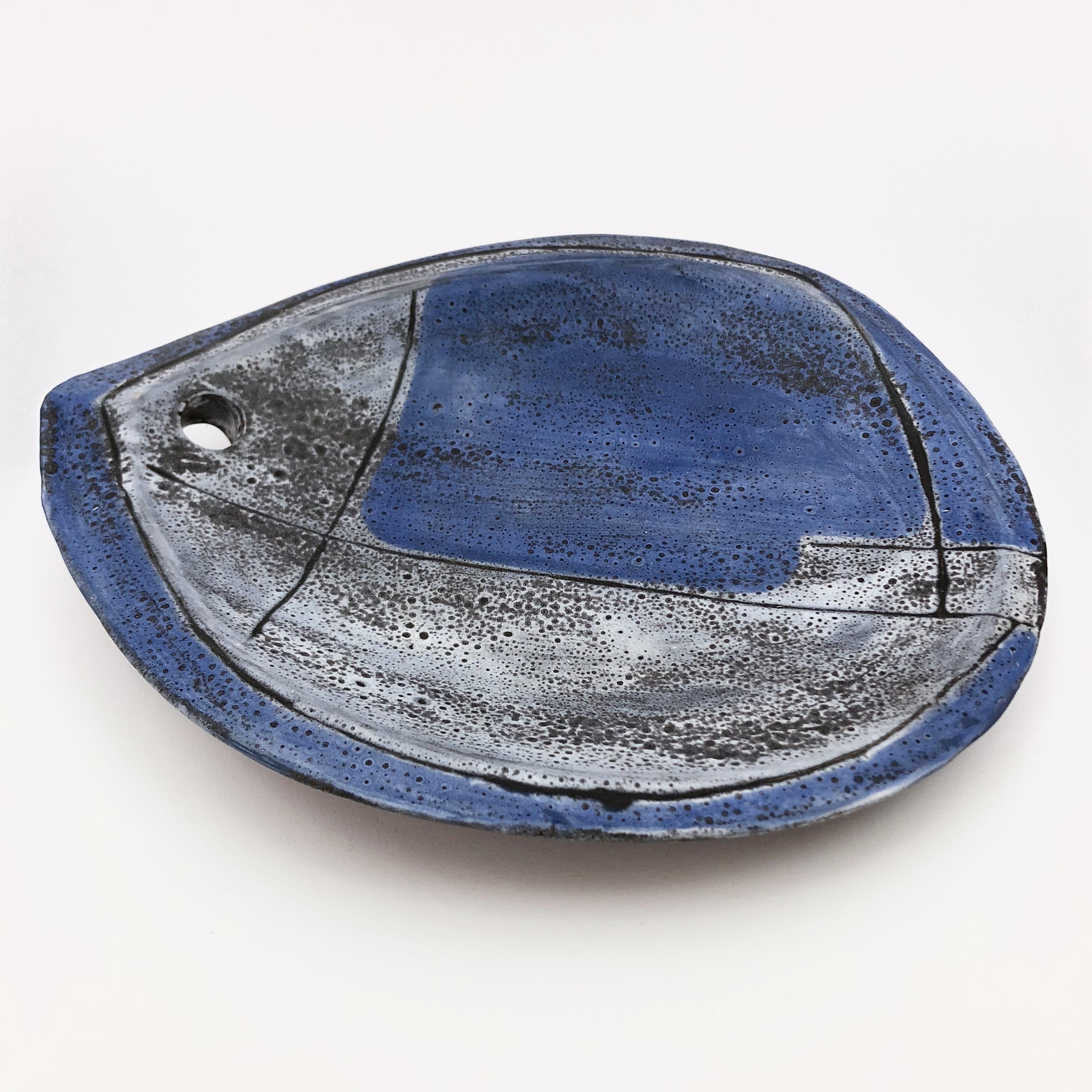 Rare decorative bowl or vide-poche, stylized fish shaped, ceramic glazed in shades of 
of mottled blue and grey-blue.
The piece is pierced and could also be hung as a wall decoration. 
Vide poche signed back with the French ceramicist's initials