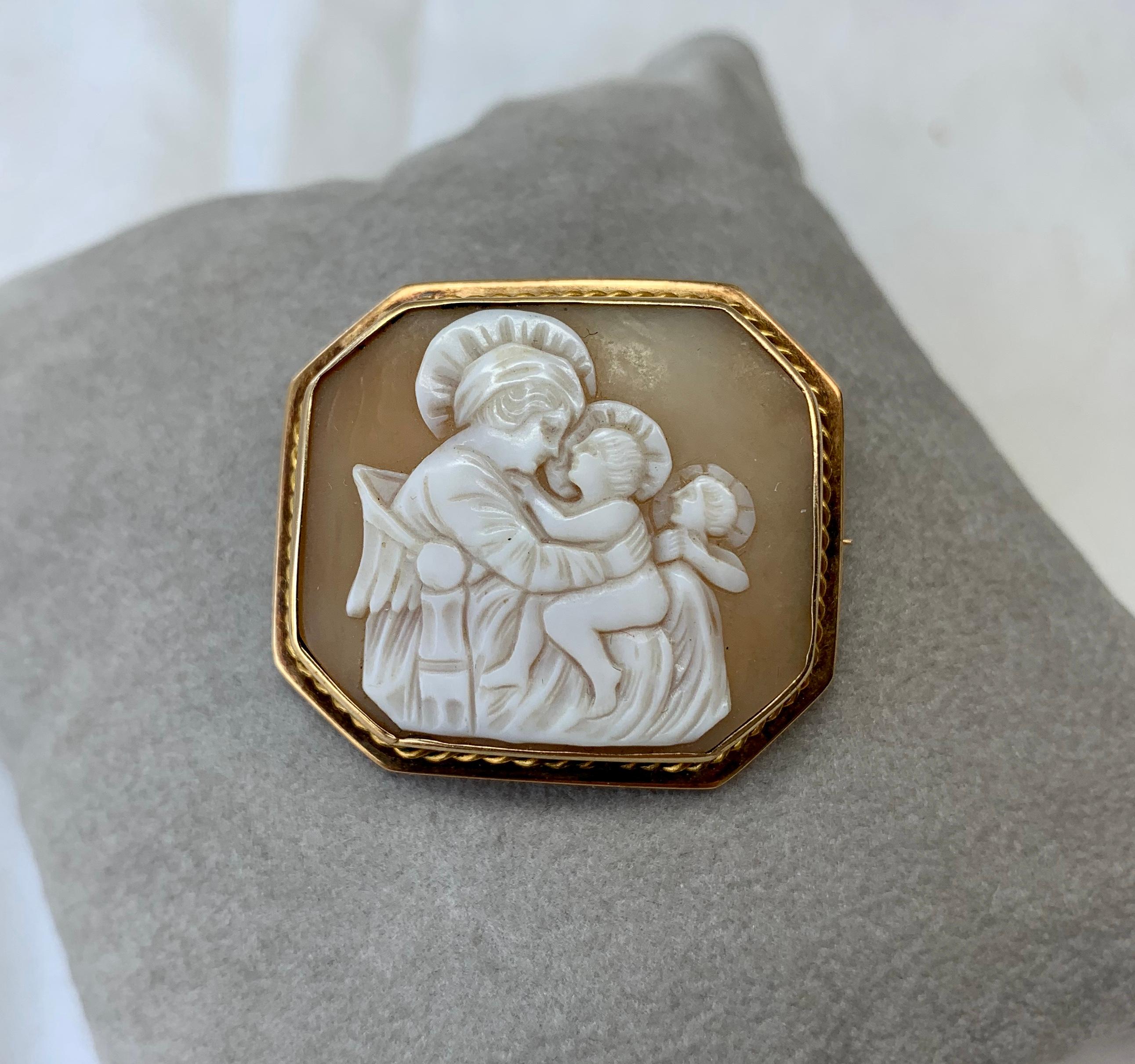 This is an absolutely stunning and very rare antique Victorian - Belle Epoque Shell Cameo Pendant Brooch Pin with a hand carved image of the Madonna with Child and a Guardian Angel watching set in a gorgeous 10 Karat Yellow Gold frame.   Cameos with