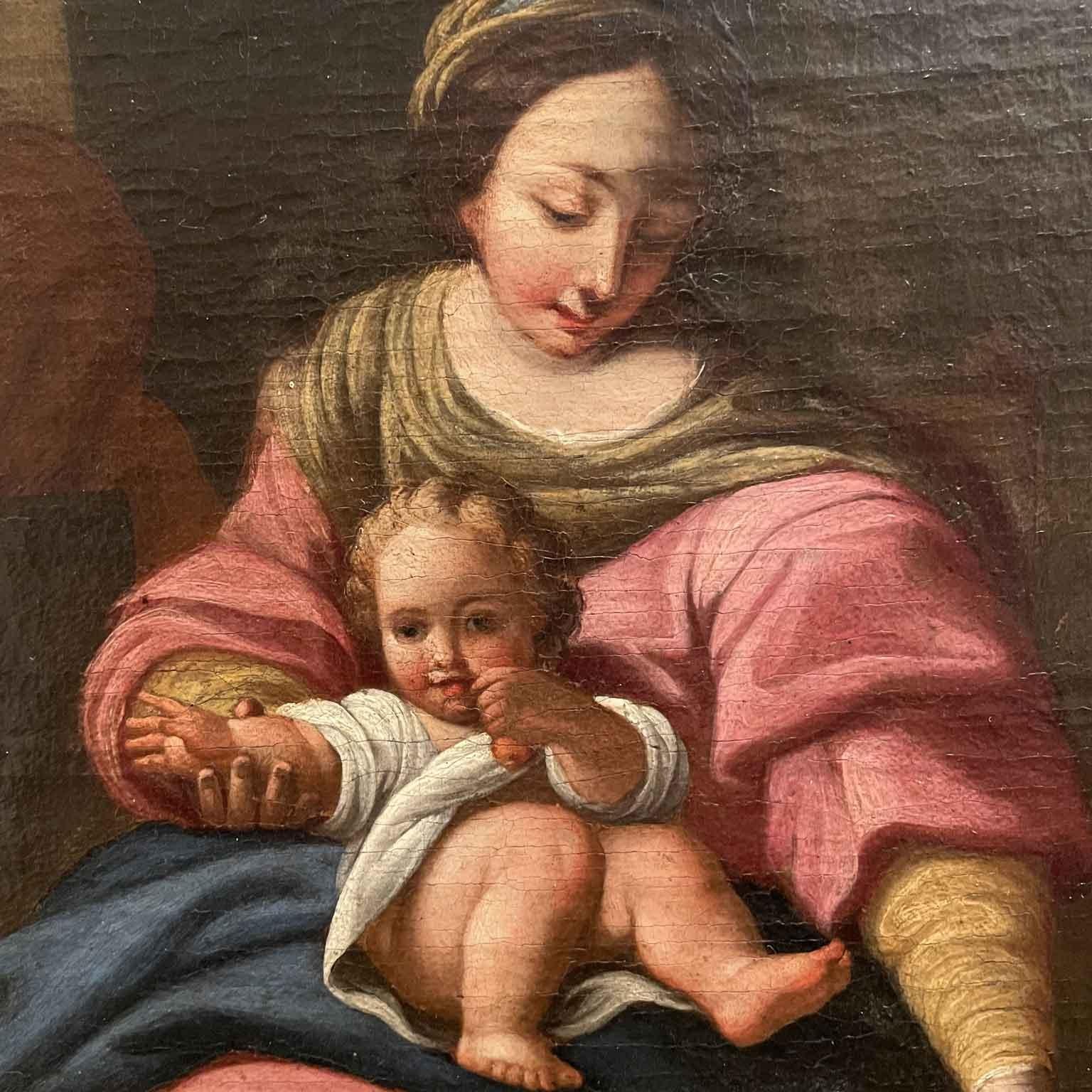 Madonna and Child with St. Joseph oil painting on canvas from the early 19th century depicting the Virgin in an interior by the side of a green curtain intent on taking textiles from a basket while holding the Child covered in a white robe on her