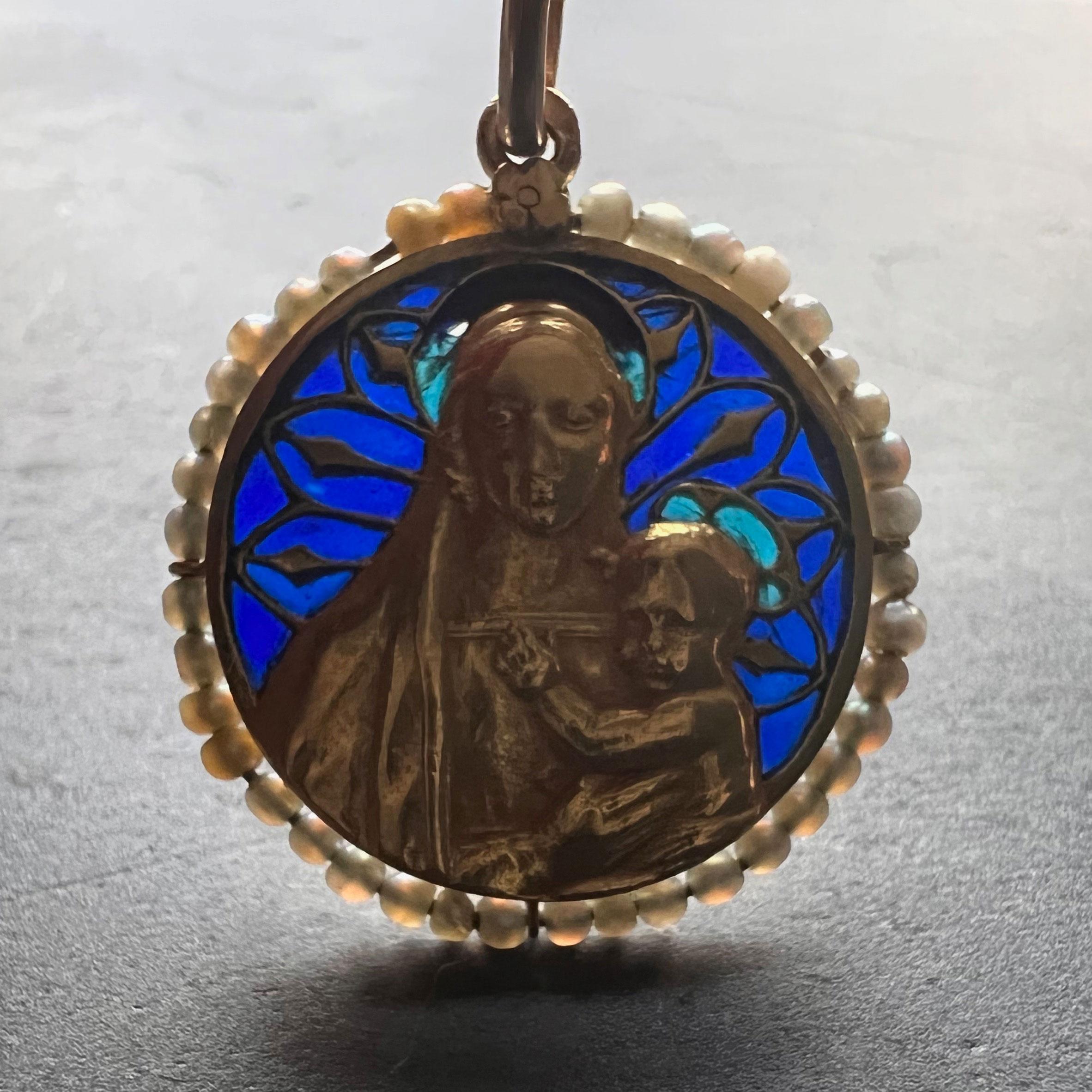 An 18 karat (18K) yellow gold pendant designed as a round medal depicting the Madonna and Child with blue plique-a-jour enamel and seed pearl surround. Stamped with the owl mark for French import and 18 karat gold, with 39 natural seed pearls.