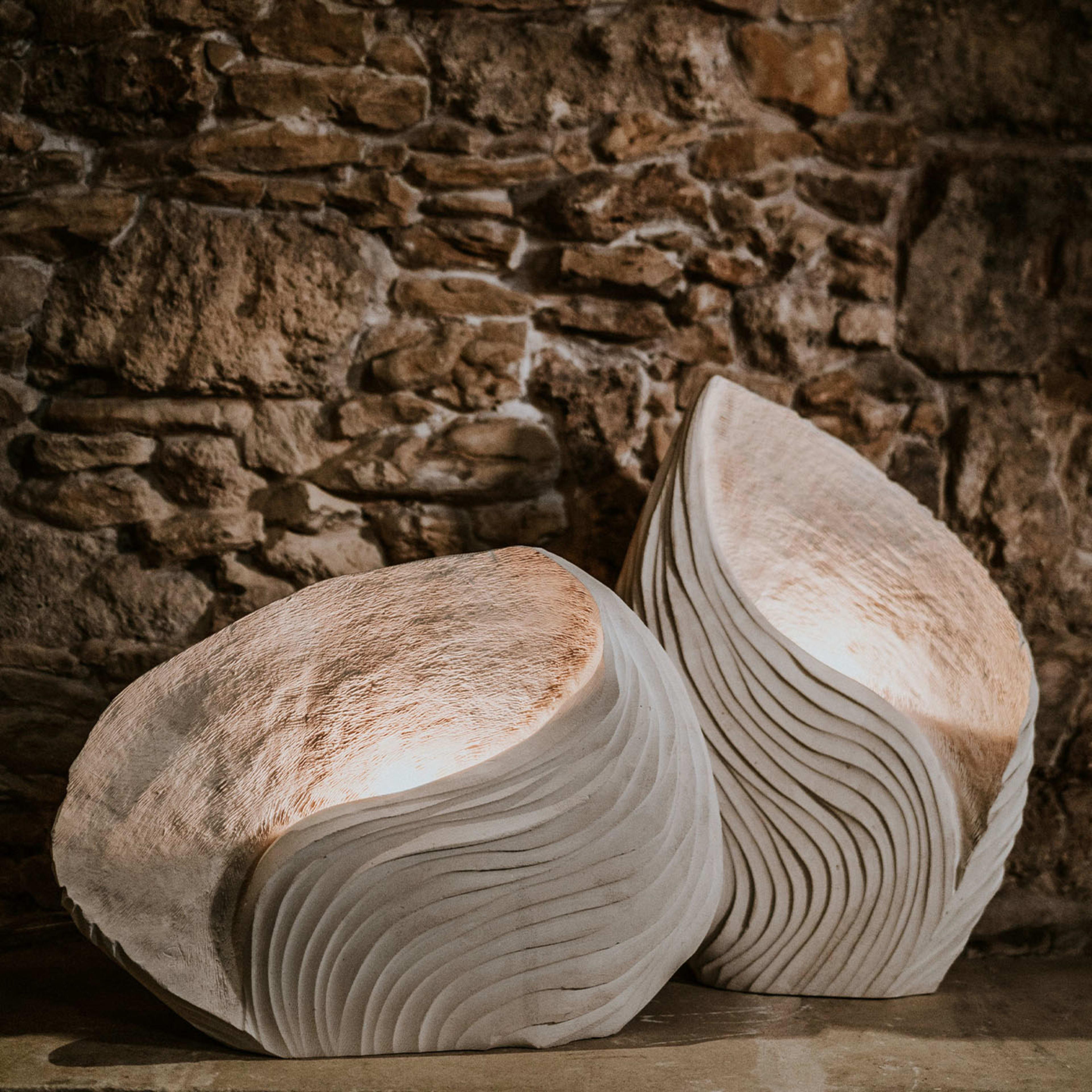 Crafted with waves in mind, this set of two luminous sculptures boasts an intricately sculpted silhouette that is rich in curves as it is rich in fossils, which are naturally present in the special marine-origin stone only quarried in the area