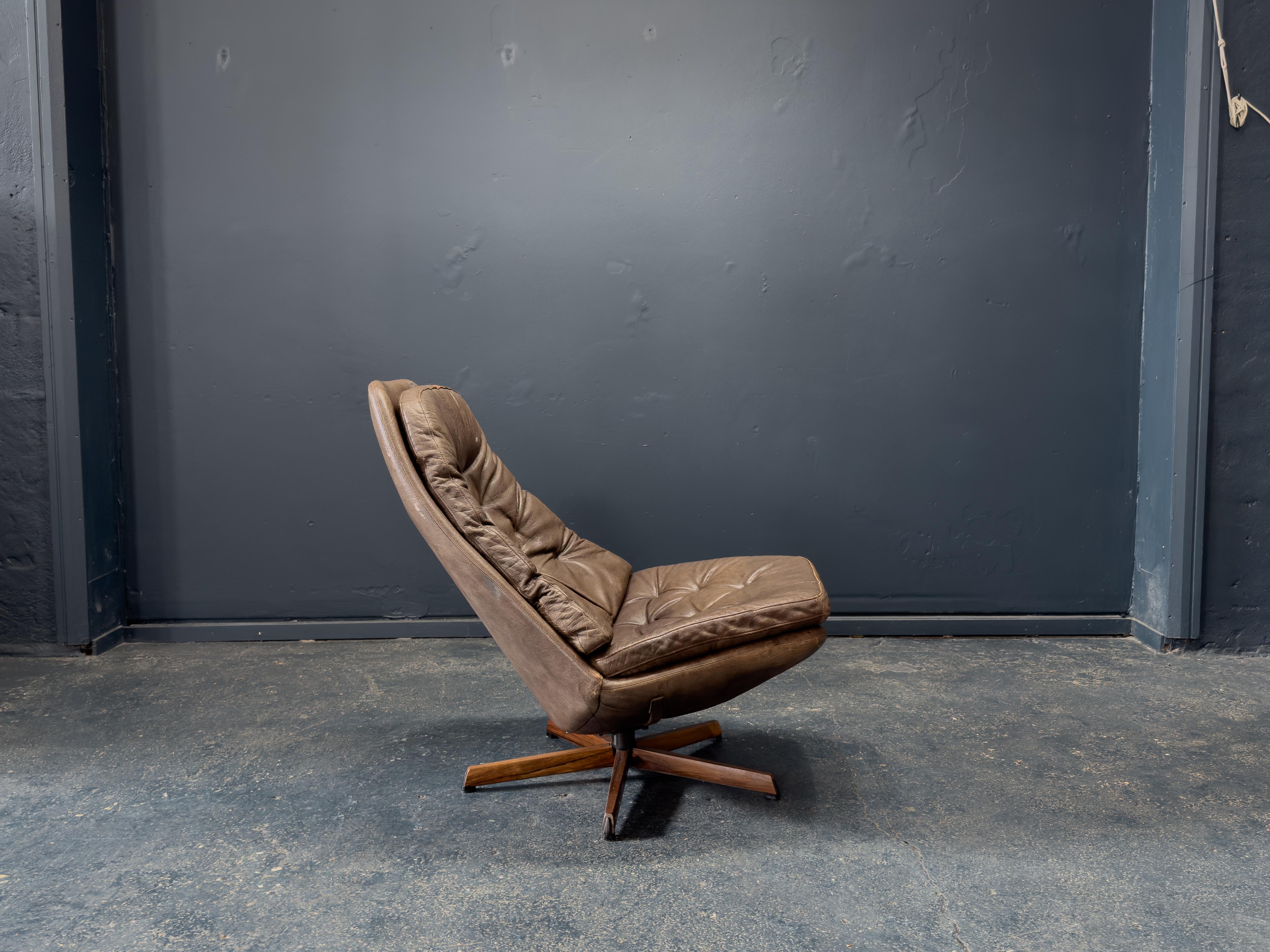 This Model 68 swivel chair by Madsen & Schubell was designed in the 1960s. Upholstered in supple, deeply patinated brown leather, the chair features a generously contoured seat and high backrest, designed to cradle the body with its signature tufted