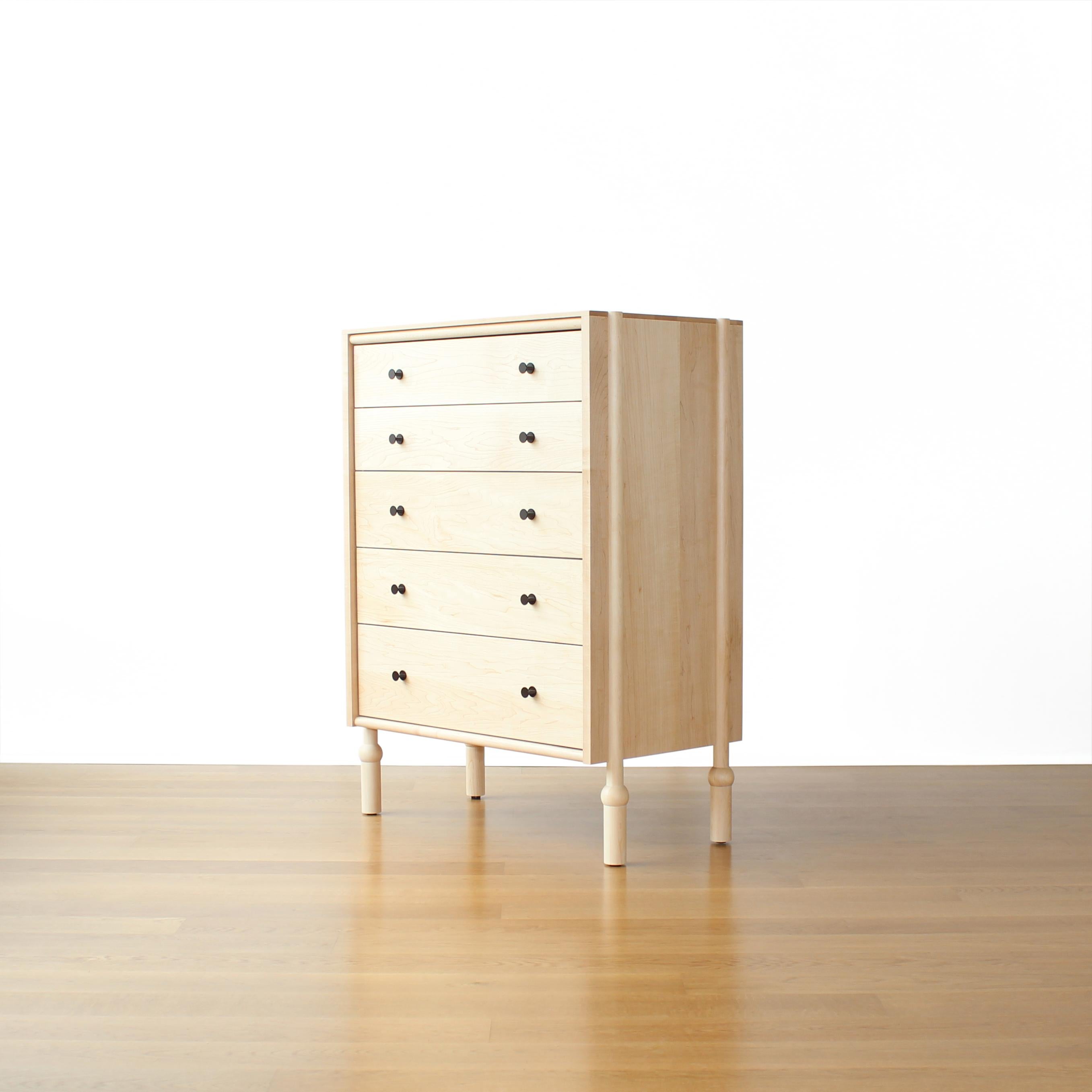 Mae highboy dresser by Crump and Kwash.

The Mae Highboy features a solid wood case, hand turned legs, and an oiled or acrylic finish. The pulls are milled from solid brass and given a patinated finish. All drawers feature premium, full extension,