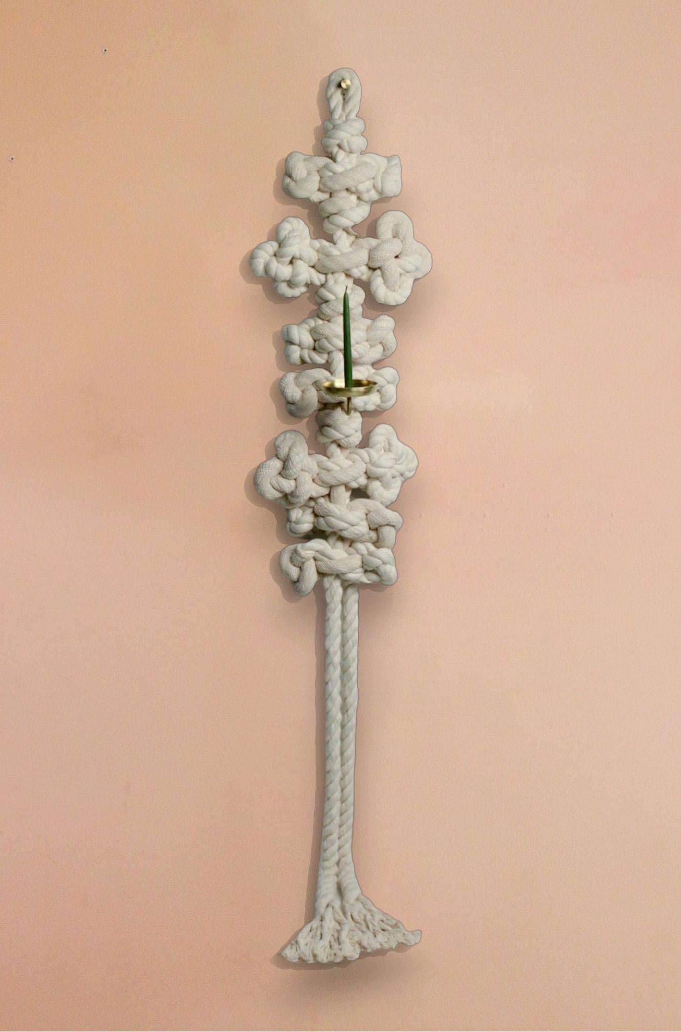 Maeduep; siete alas, 2023 por WKND Lab
De la serie Atando Deseos
Cuerda de algodón, latón
Color: Marfil, dorado
Uso: Candelabro / Quemador de Incienso a Contraflujo

Un candelabro construido con cuerda de algodón, carcasa de viscosa y latón. La