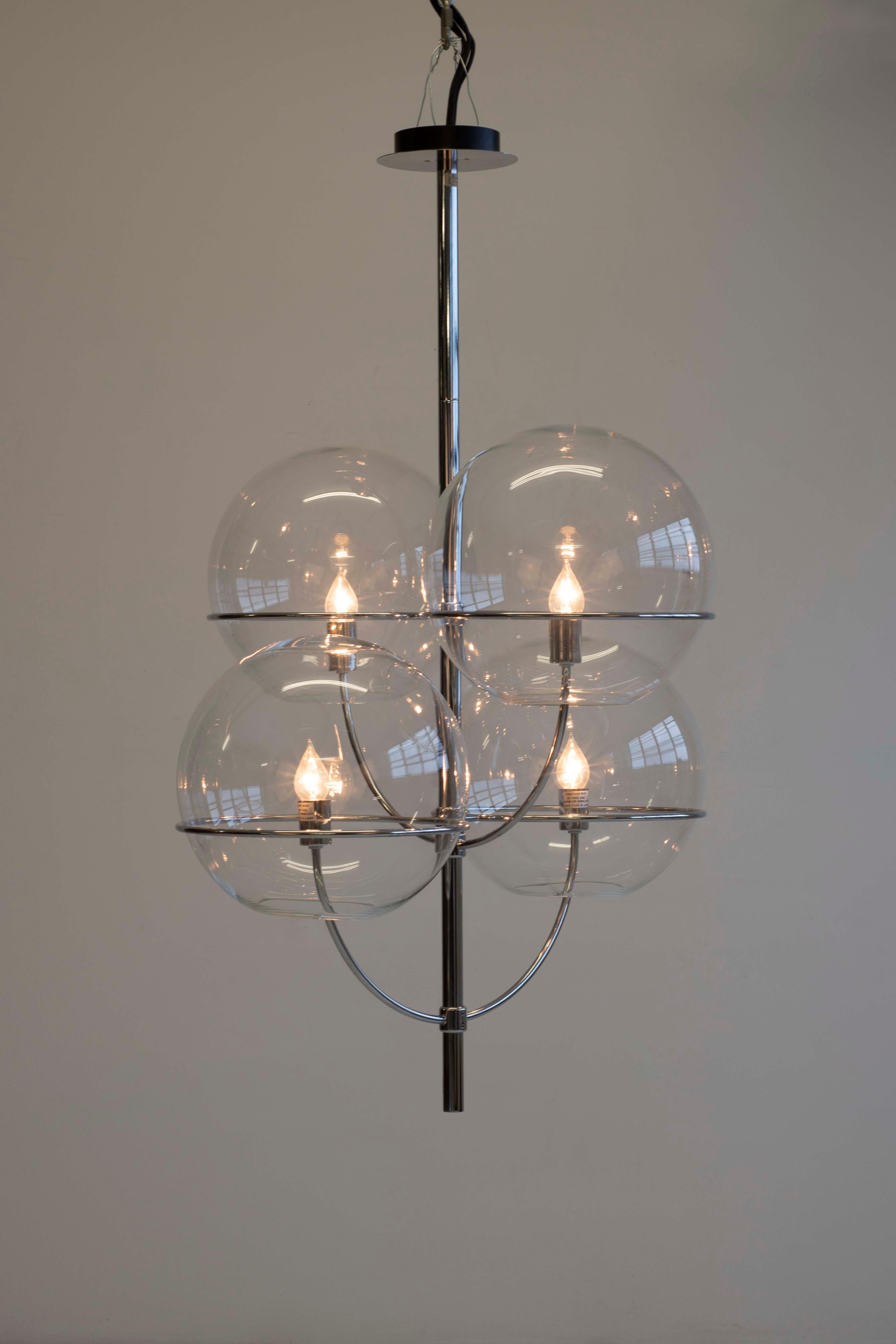 Lyndon de Vico Magistretti pour Oluce ; corps en forme de candélabre à finition chromée, renfermant des sphères en verre transparent, à l'intérieur desquelles se trouve l'ampoule.

 