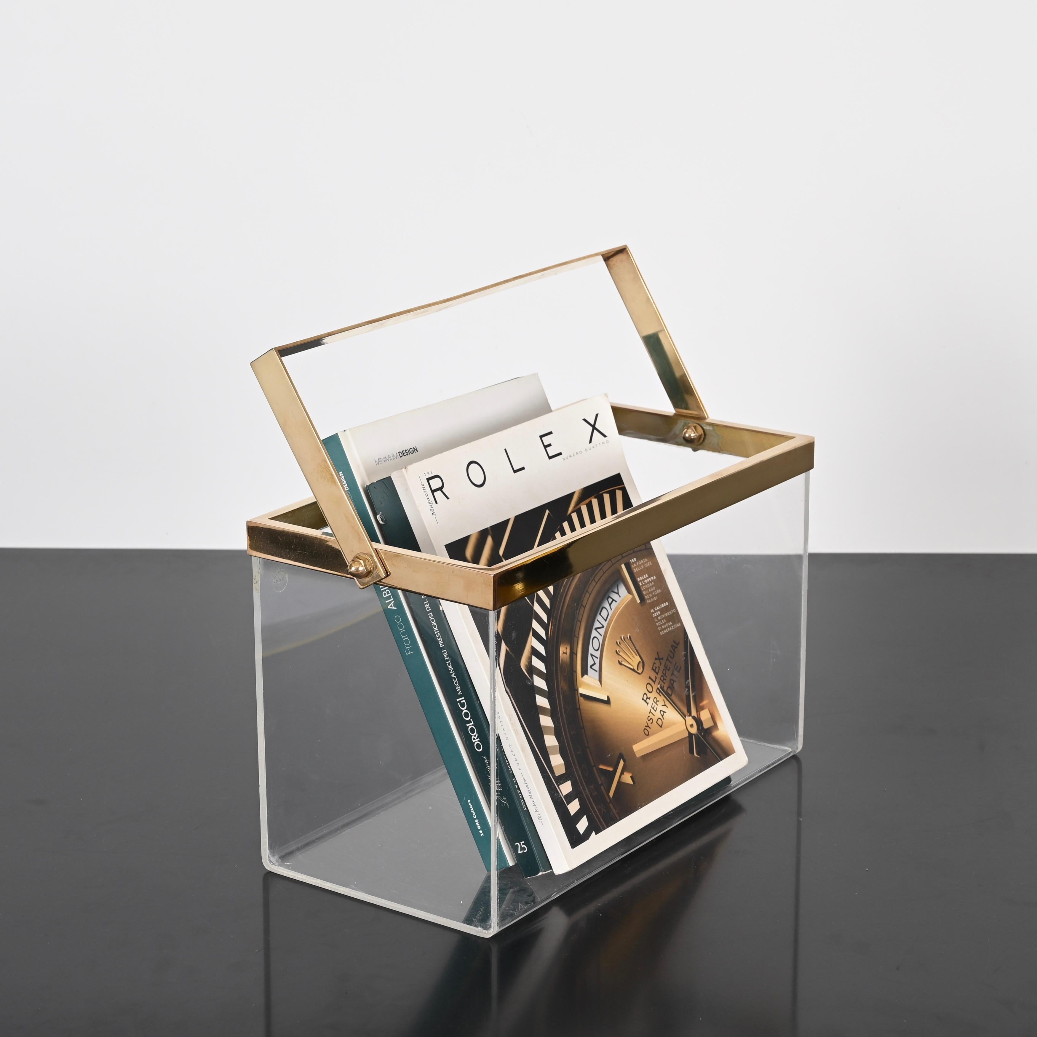 Elegant magazine rack fully made in clear lucite and solid brass. This charming object was produced in Italy during the 1970s clearly in the style of Romeo Rega. 

This delightful item is in amazing conditions and can be used either as magazine or