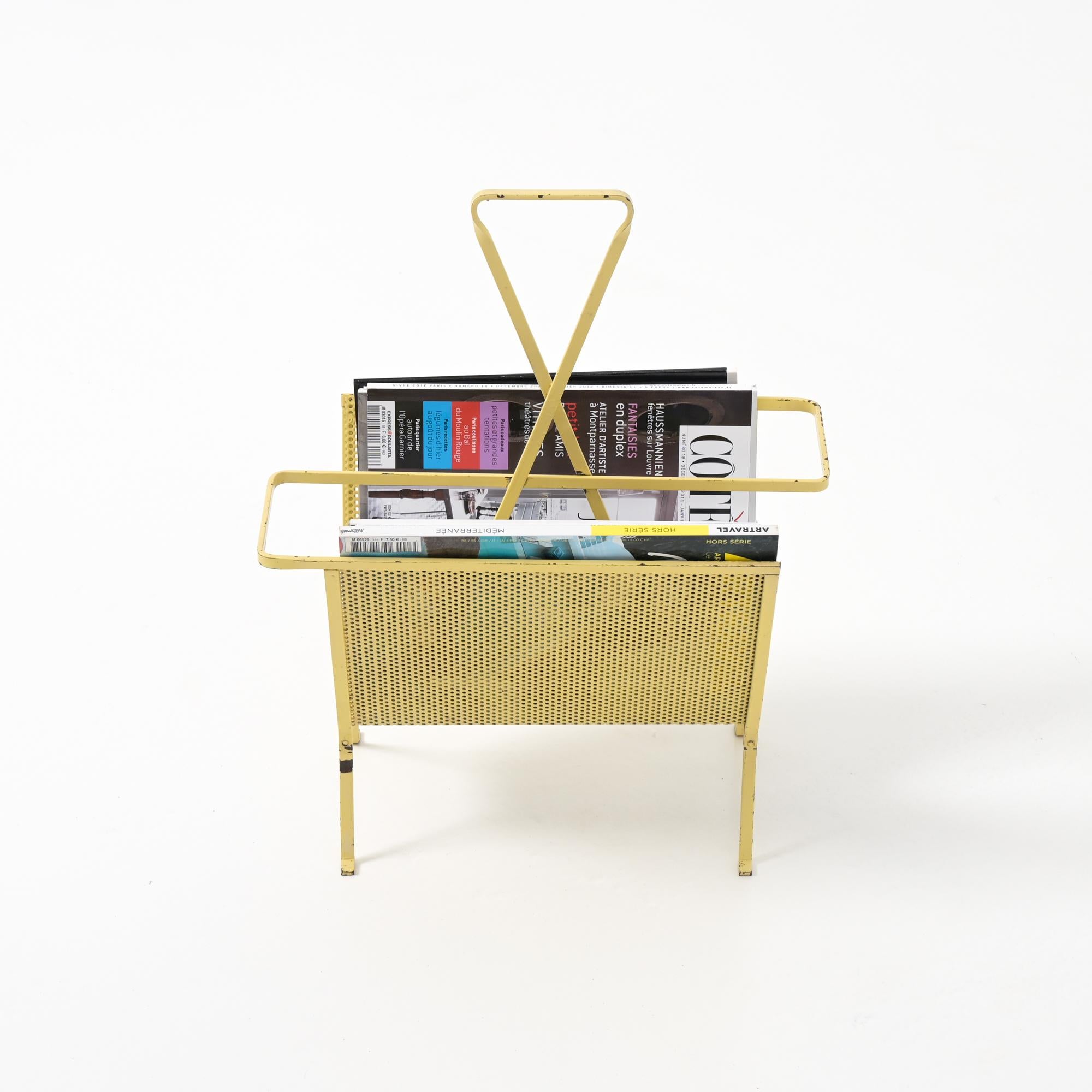 This pure and elegant magazine stand was designed by Mathieu Matégot (1910-2001) in the 1950s and manufactured by Artimeta.

The stand is made of soft yellow lacquered folded and perforated metal. The shape has a beautiful simplicity and consists of