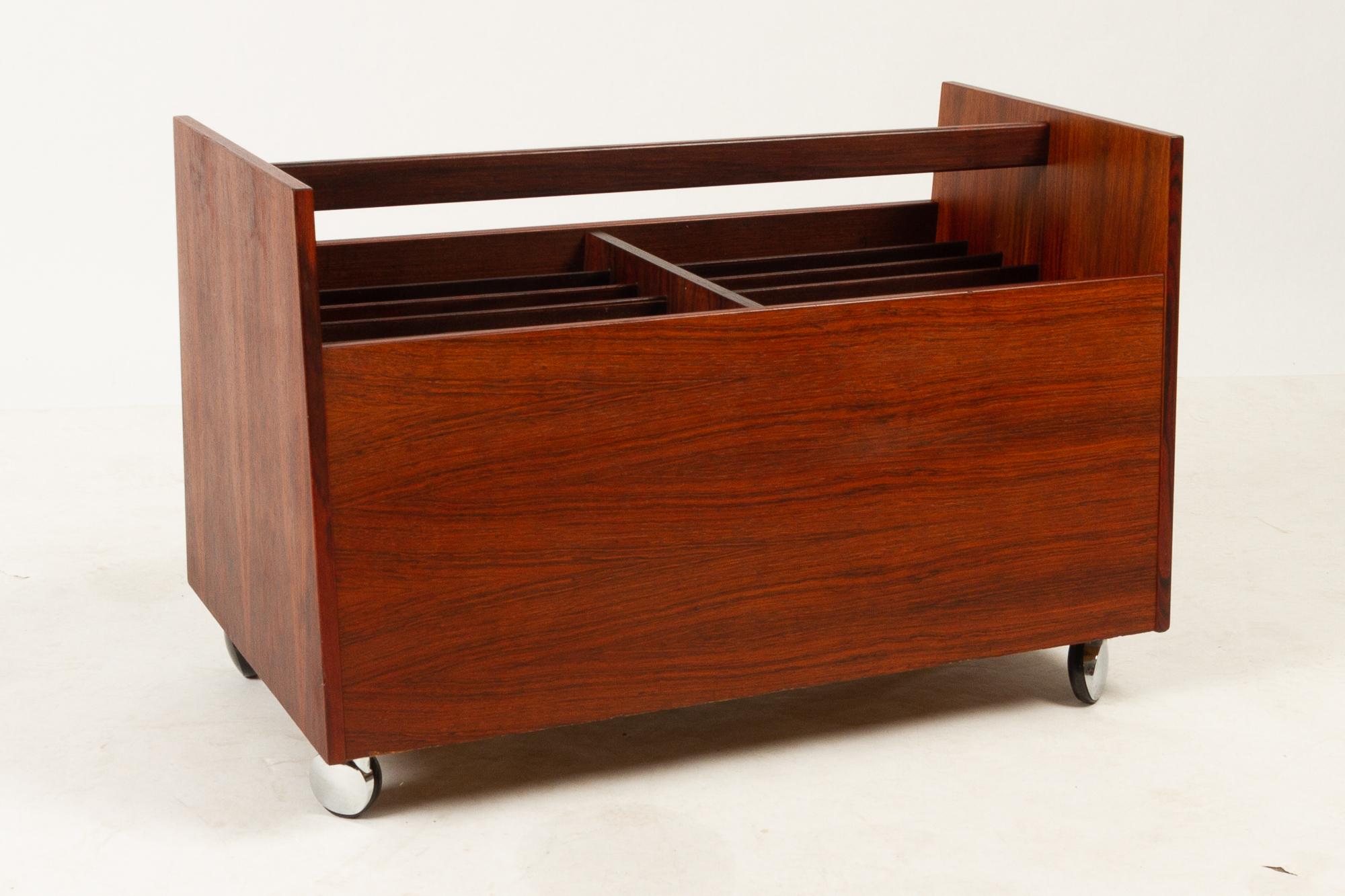 Magazine rack in rosewood by Rolf Hesland for Bruksbo, 1960s.
Mid-Century Modern magazine or vinyl cart. Rosewood veneer sides. Divided into 12 slots, that will fit vinyl records or magazines and newspapers. Four wheels. Beautiful veneer with small